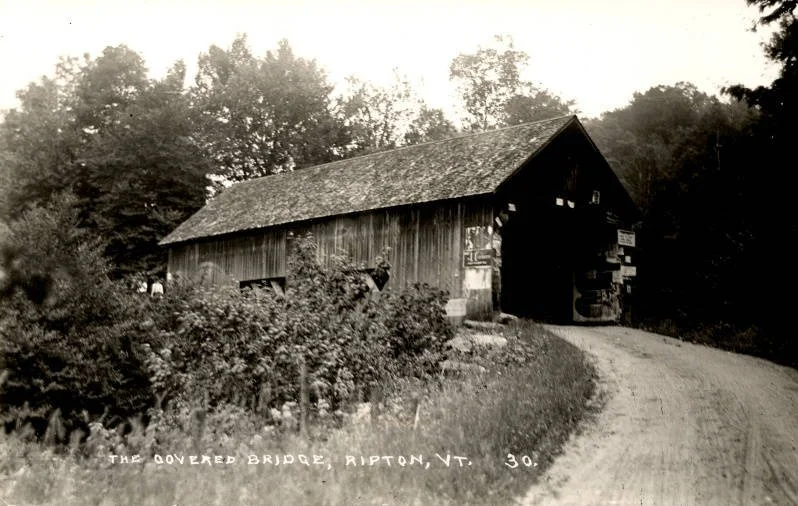Covered bridge in Ripton, Vermont, with several signs posted at near end and several partially hidden people at the far end.

Middlebury College Special Collections, Middlebury, Vermont