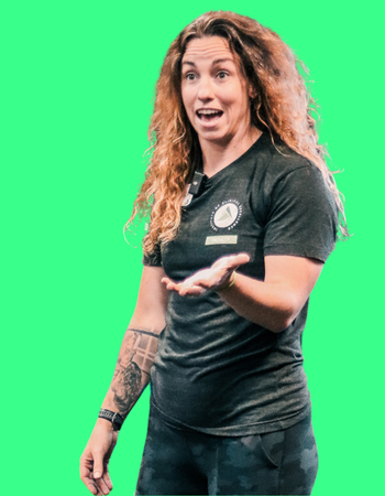 A woman with curly hair wearing a black polo shirt with a logo on it, gesturing with her hand and smiling, against a green background.