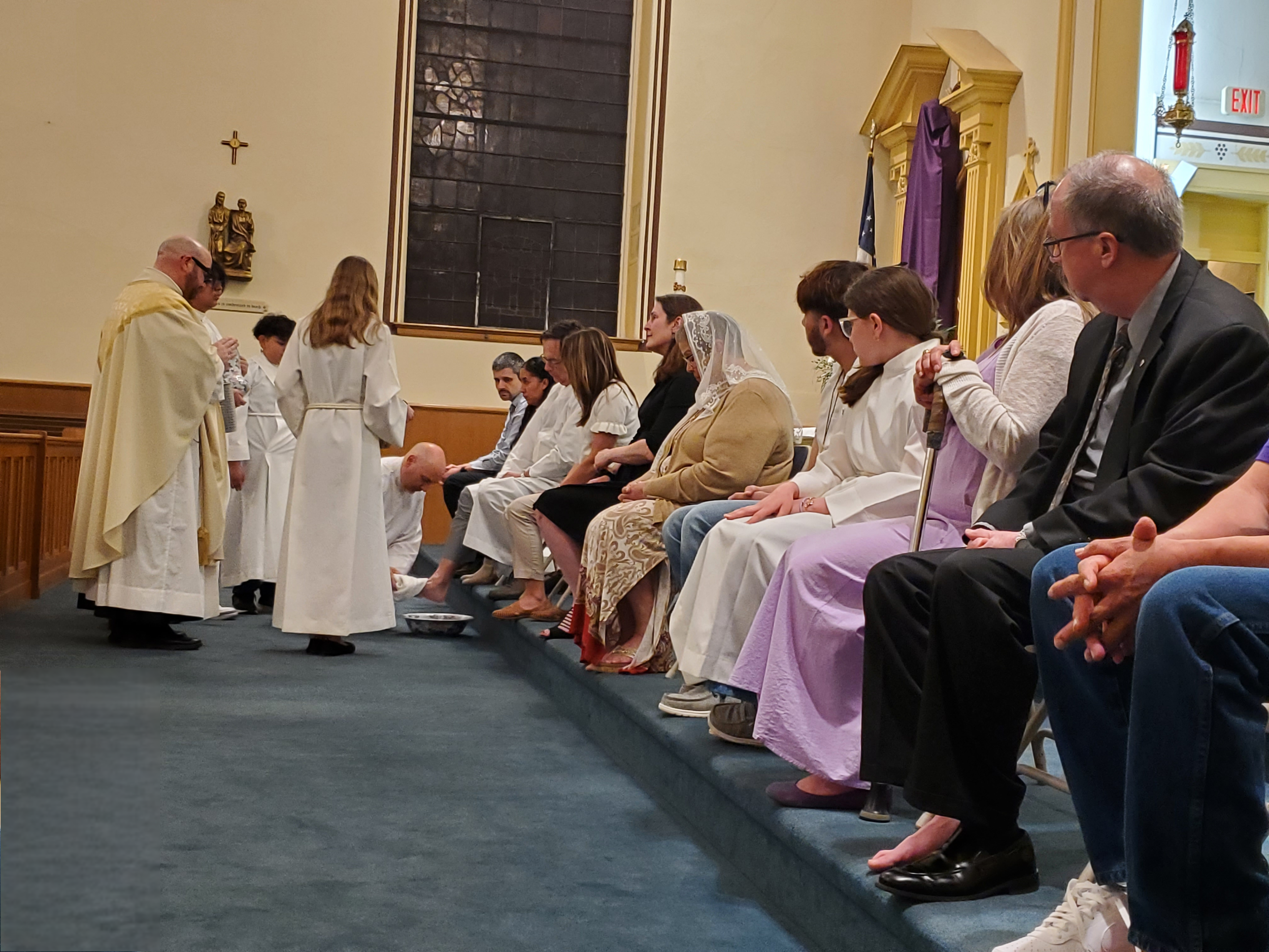 Father washes the feet of parishioners, just as Jesus washed his disciples feet on the night of the Last Supper.