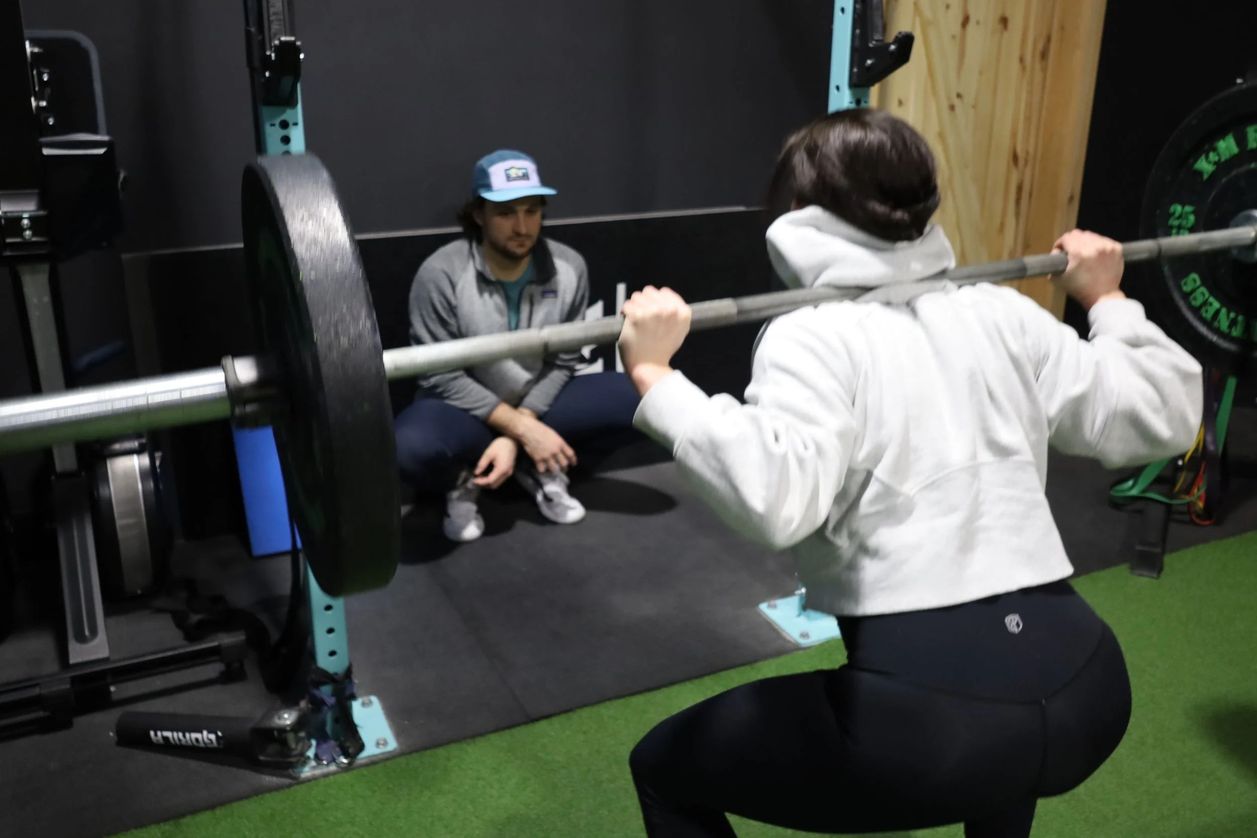 physiotherapist performing a movement assessment with an active patient in a modern clinic setting