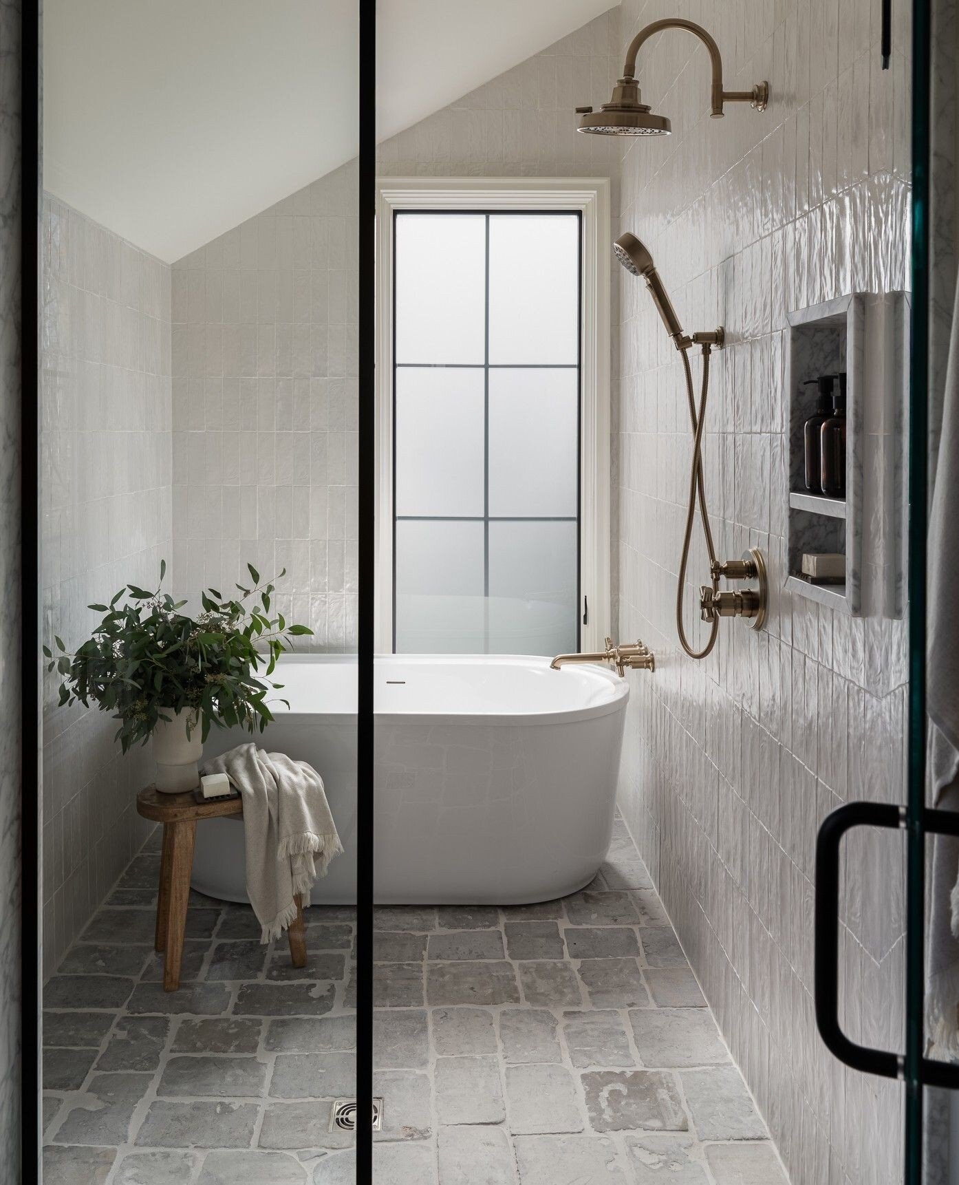 The SD Haven master bath features reclaimed cobblestone, soaking tub and brass fixtures. I think it creates a serene and relaxing atmosphere in this bath.⁠
⁠
⁠
#aanovodesignbuild | Photo by @sarahshieldsphoto 📷⁠
⁠
#sdhaven #bathroomdesign #showerdes