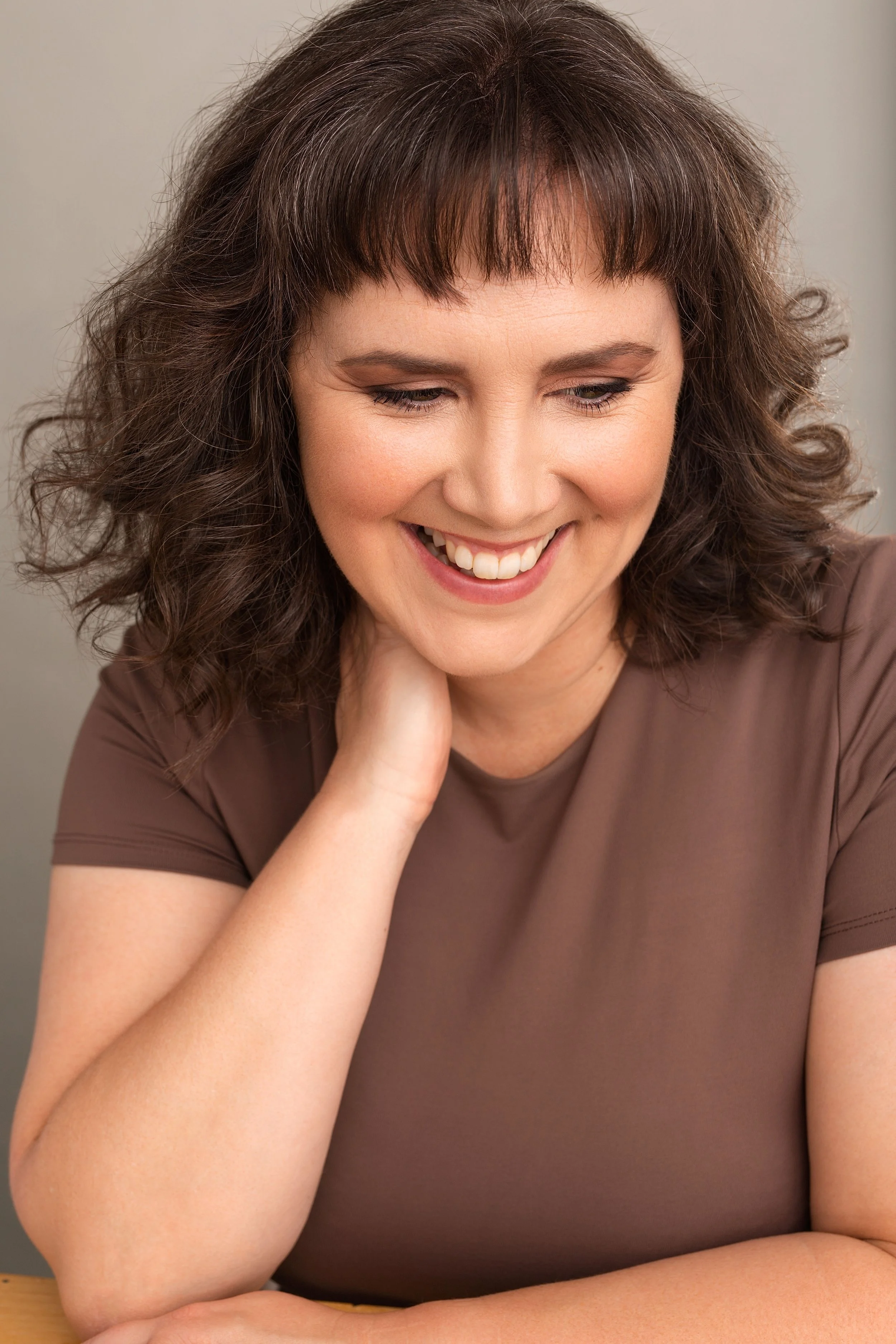 A smiling professional woman enjoys her headshot photoshoot in Vancouver