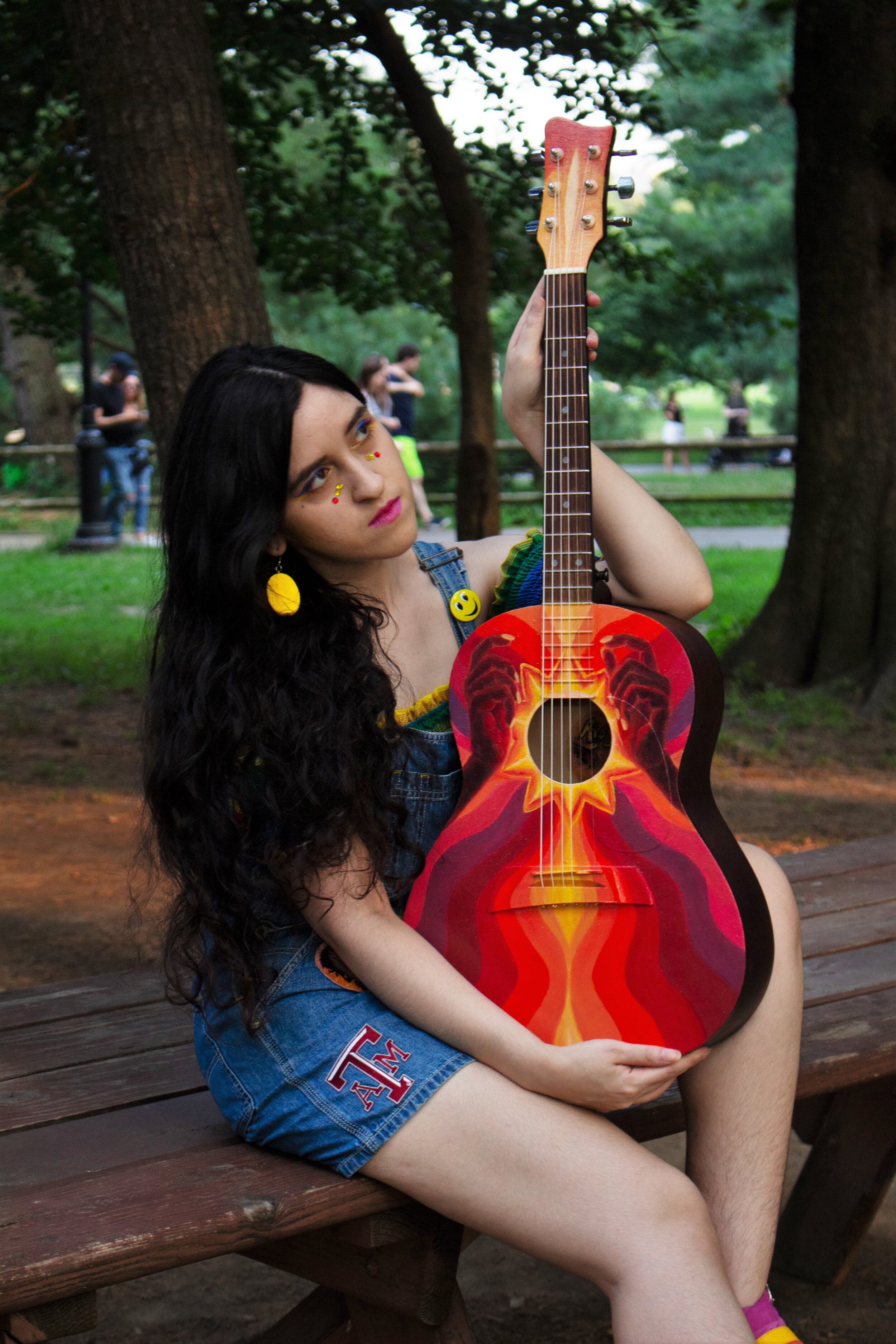Amanda Riojas holding rainbow hands lgbt queer guitar in central park