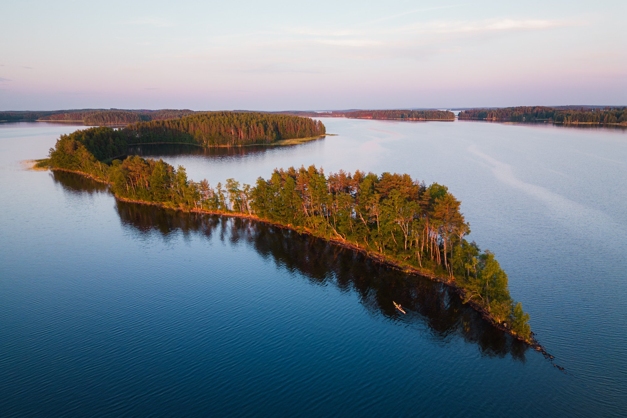 A small islan in Finnish lake and a kayak padling next to it_Sunset in summer time Finland_Adventure photography©Sami Laitinen.jpg