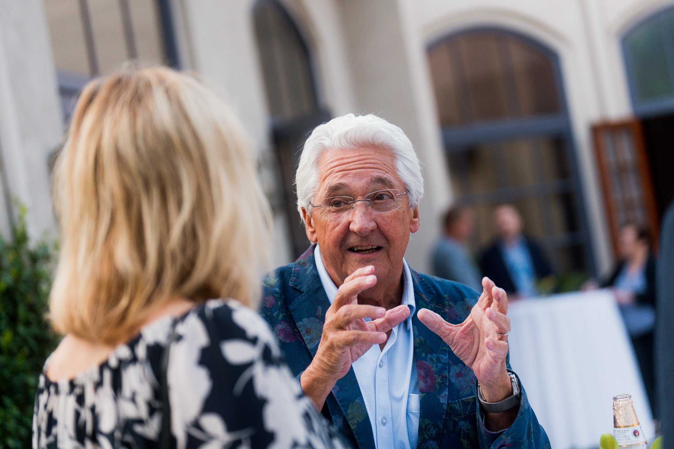 Grey haired man explaining something to other person in a event©Sami Laitinen.jpg