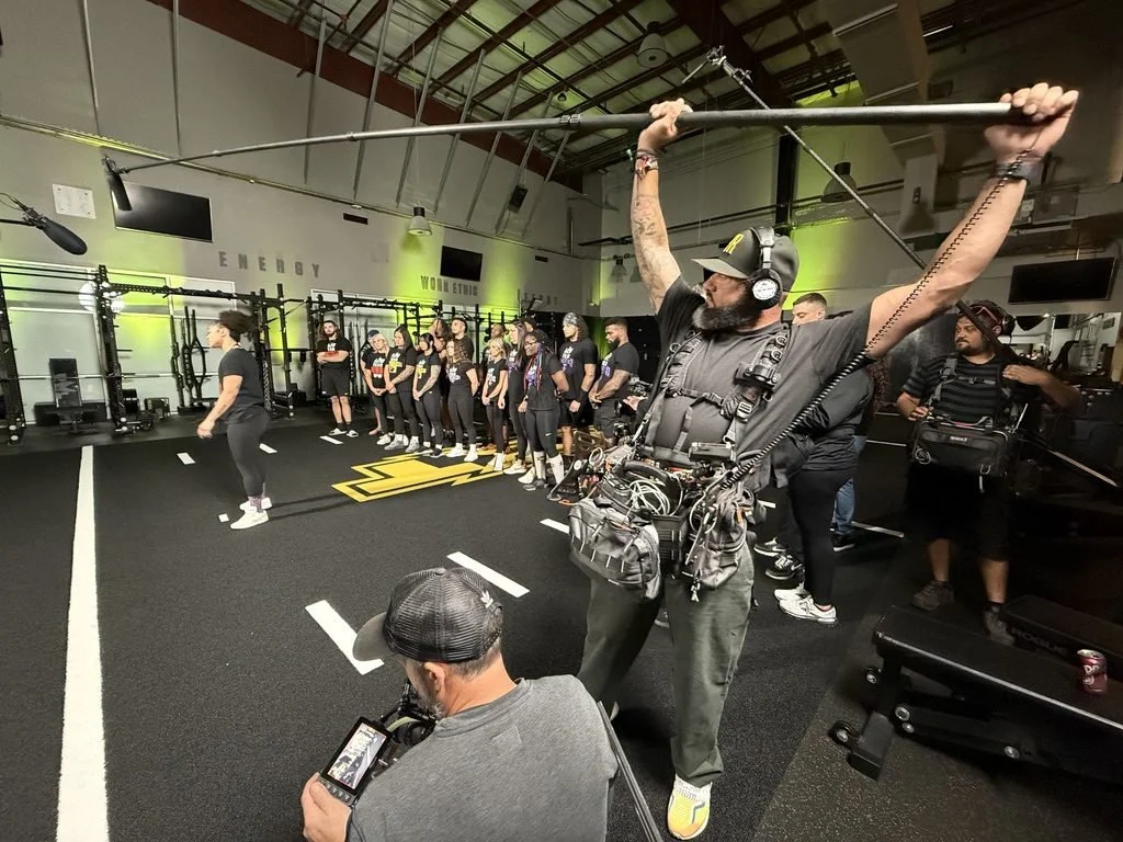Edson Alvarez booming a group scene for an unscripted series in a training gym       Caption: Unscripted series, training facility