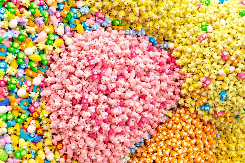 Colorful assortment of small animal-shaped beads in pink, yellow, orange, green, blue, and purple.