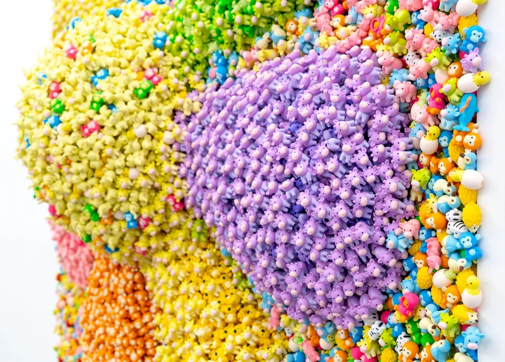 Colorful collection of tiny toy figures arranged in a gradient pattern.