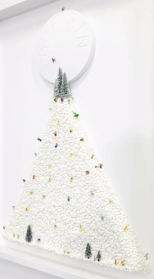 White Christmas tree made of cotton balls, decorated with small figurines and miniature trees, topped with a clock.