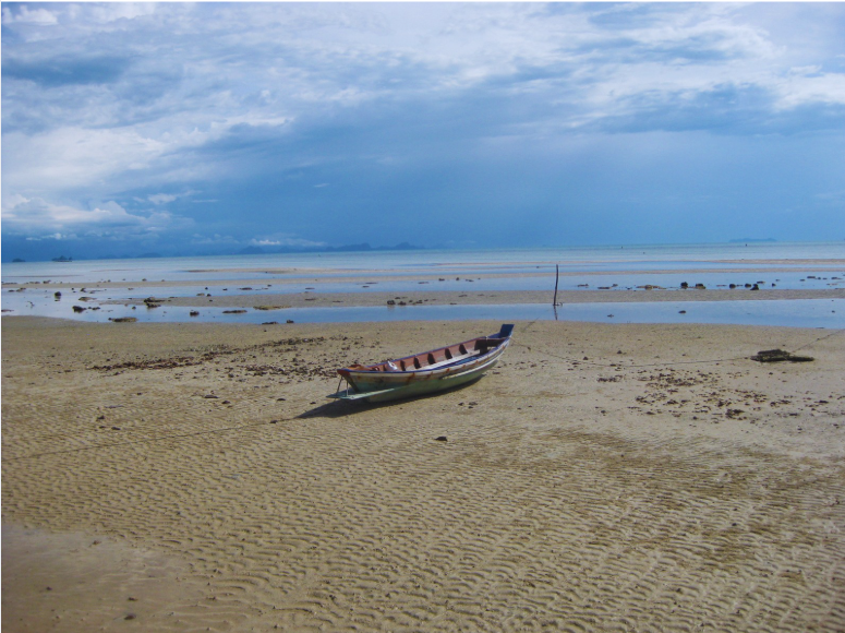Thailändisches Fischerboot am Strand bei Ebbe