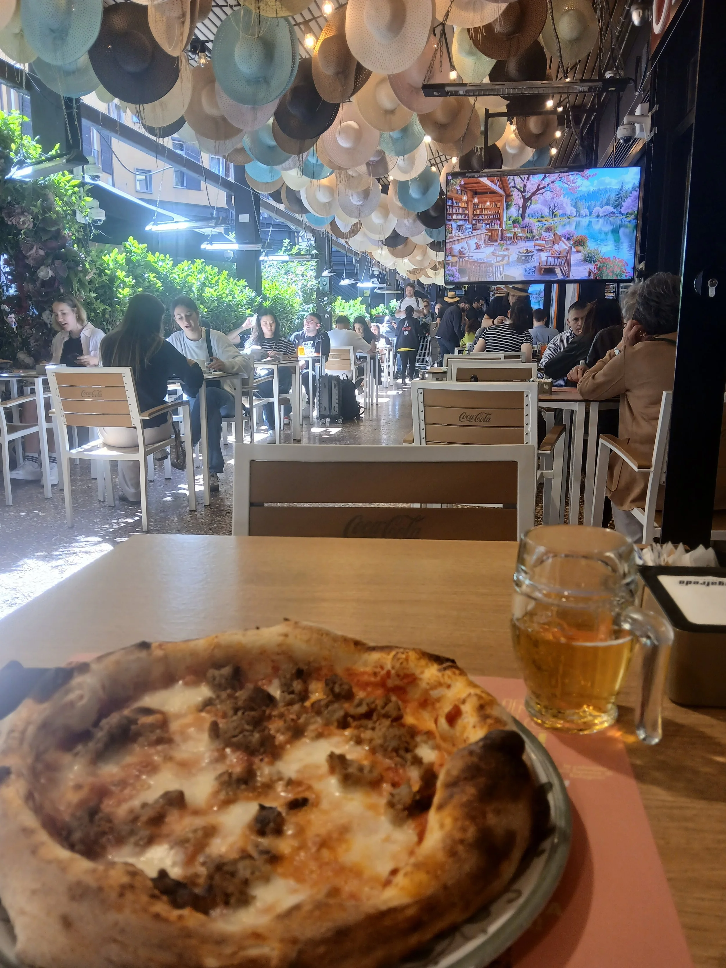 Pizza und Bier in einem Innenhof eines Restaurants in Bologna