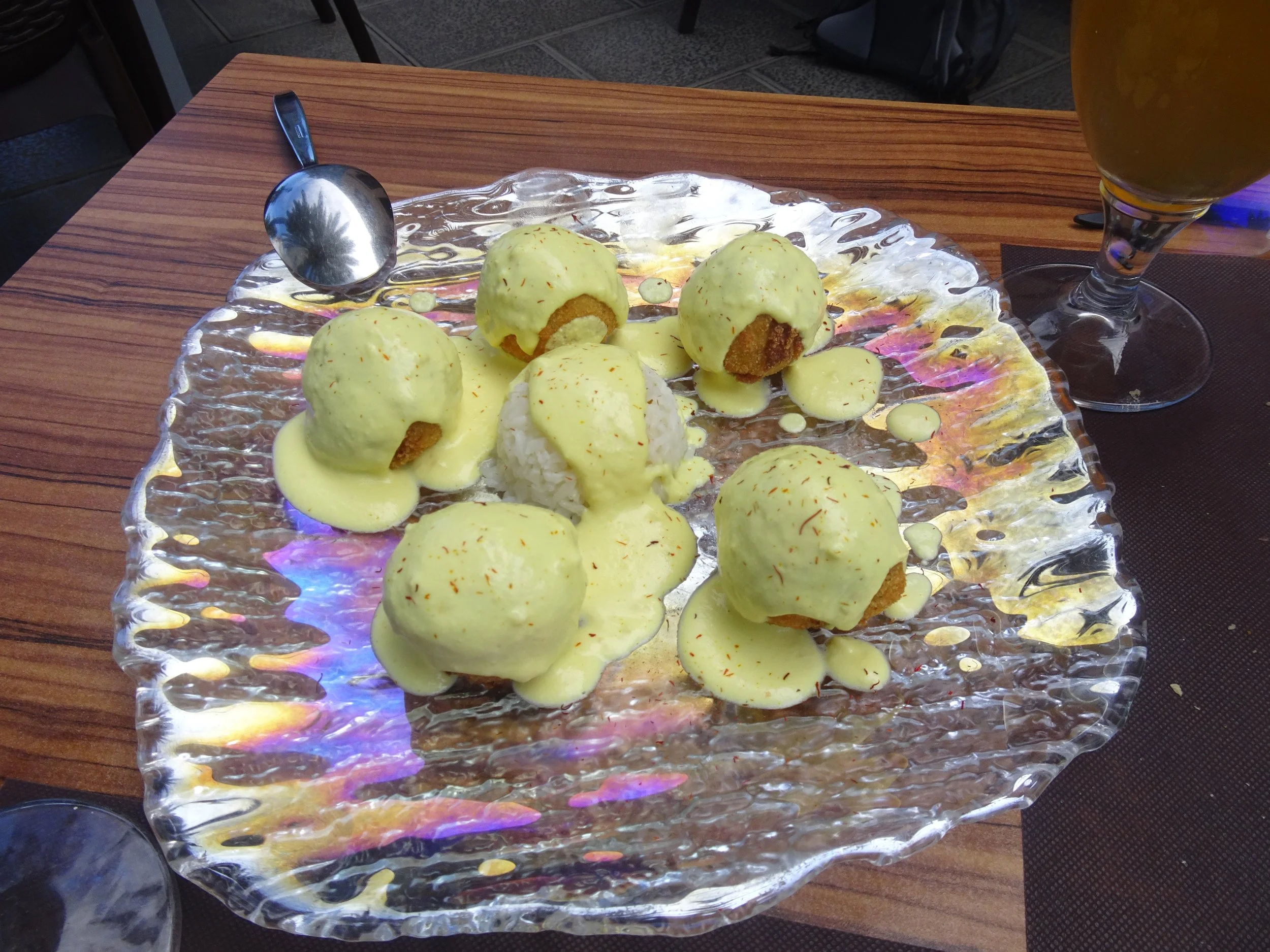 Tintenfischbällchen mit Safran auf einem Glasteller