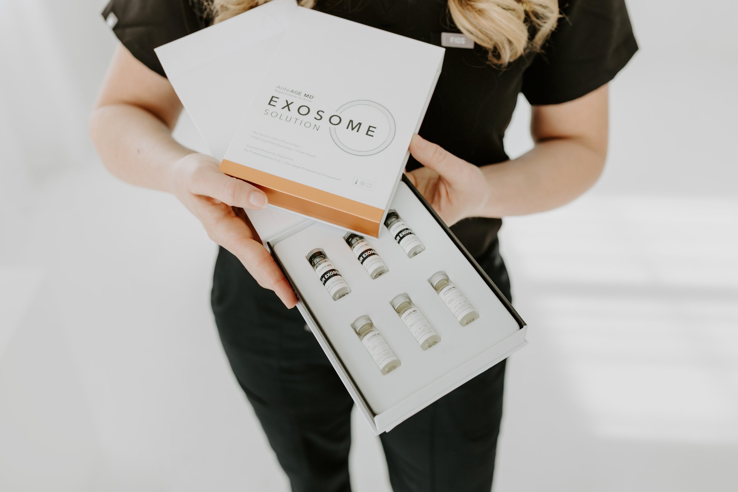 Person holding a box of Exosome Solution vials.