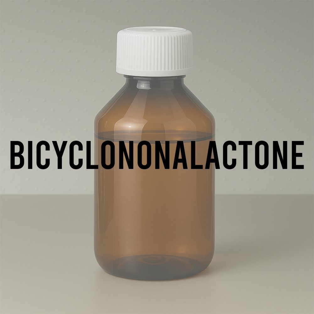 Amber glass laboratory bottle labeled “BICYCLONONALACTONE” with white cap; standard perfumery container used for storing synthetic creamy-lactonic aroma chemicals.