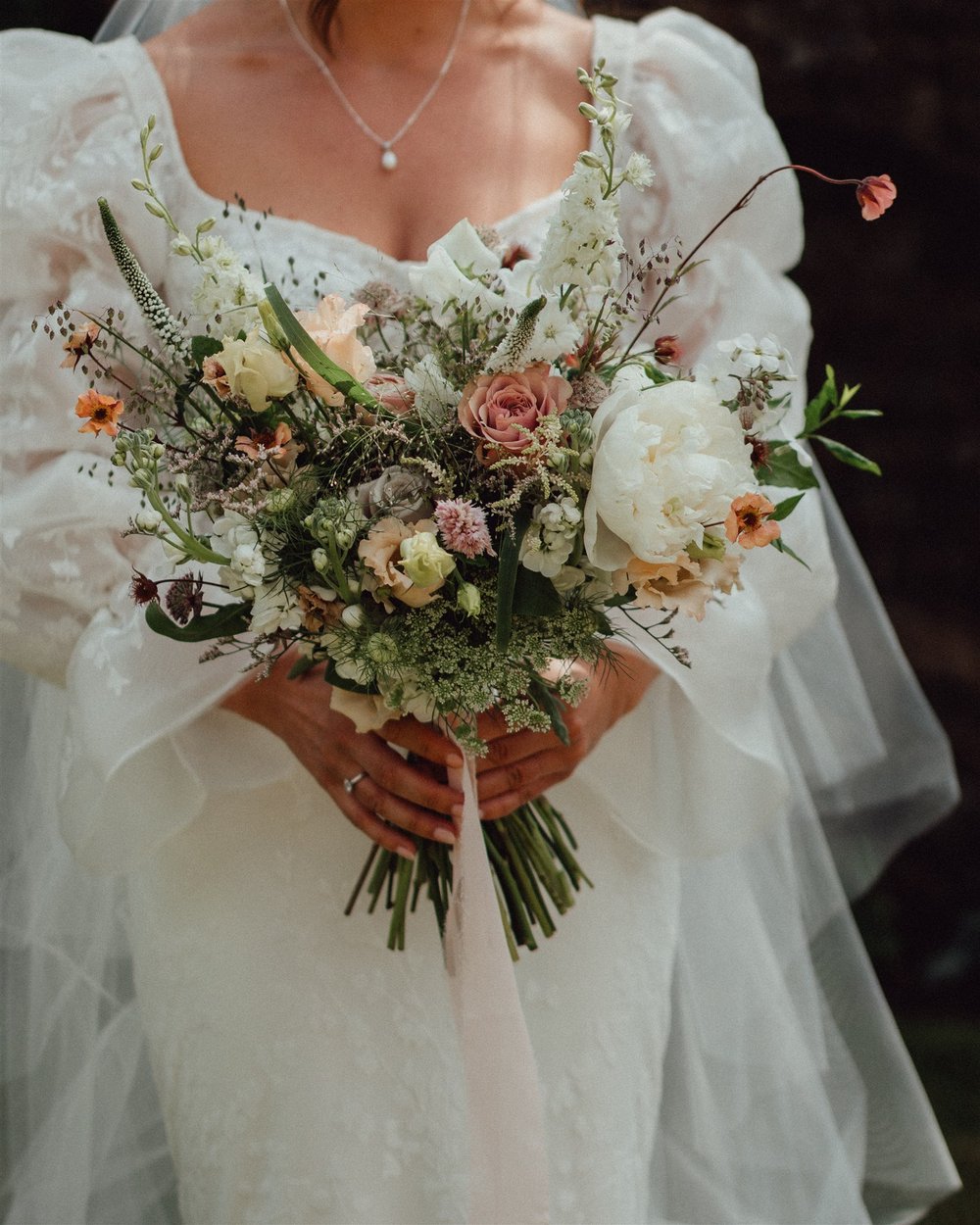 English garden bridal bouquet being held by bride in a couture gown