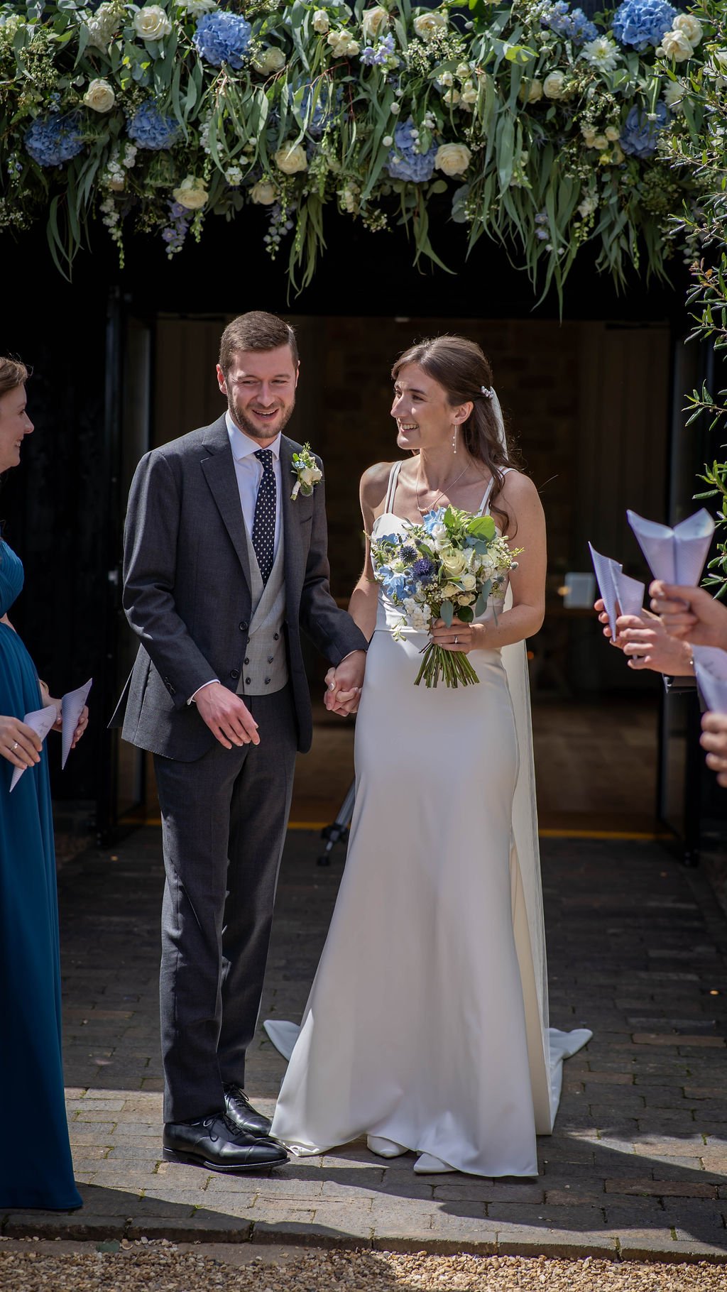 Bride and groom framed by a flower arch at Primrose Hill Farm wedding venue in Oxfordshire