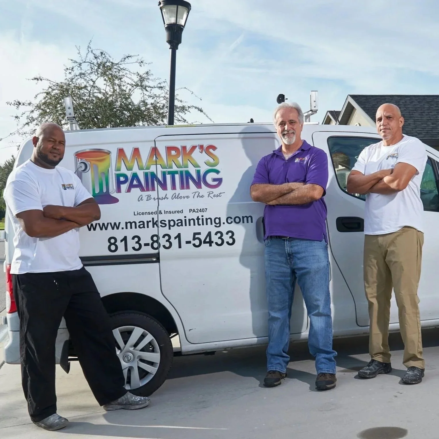 Professional painting team posing beside branded service van, illustrating experienced Tampa contractors discussing Behr Ultra versus Marquee paint performance.