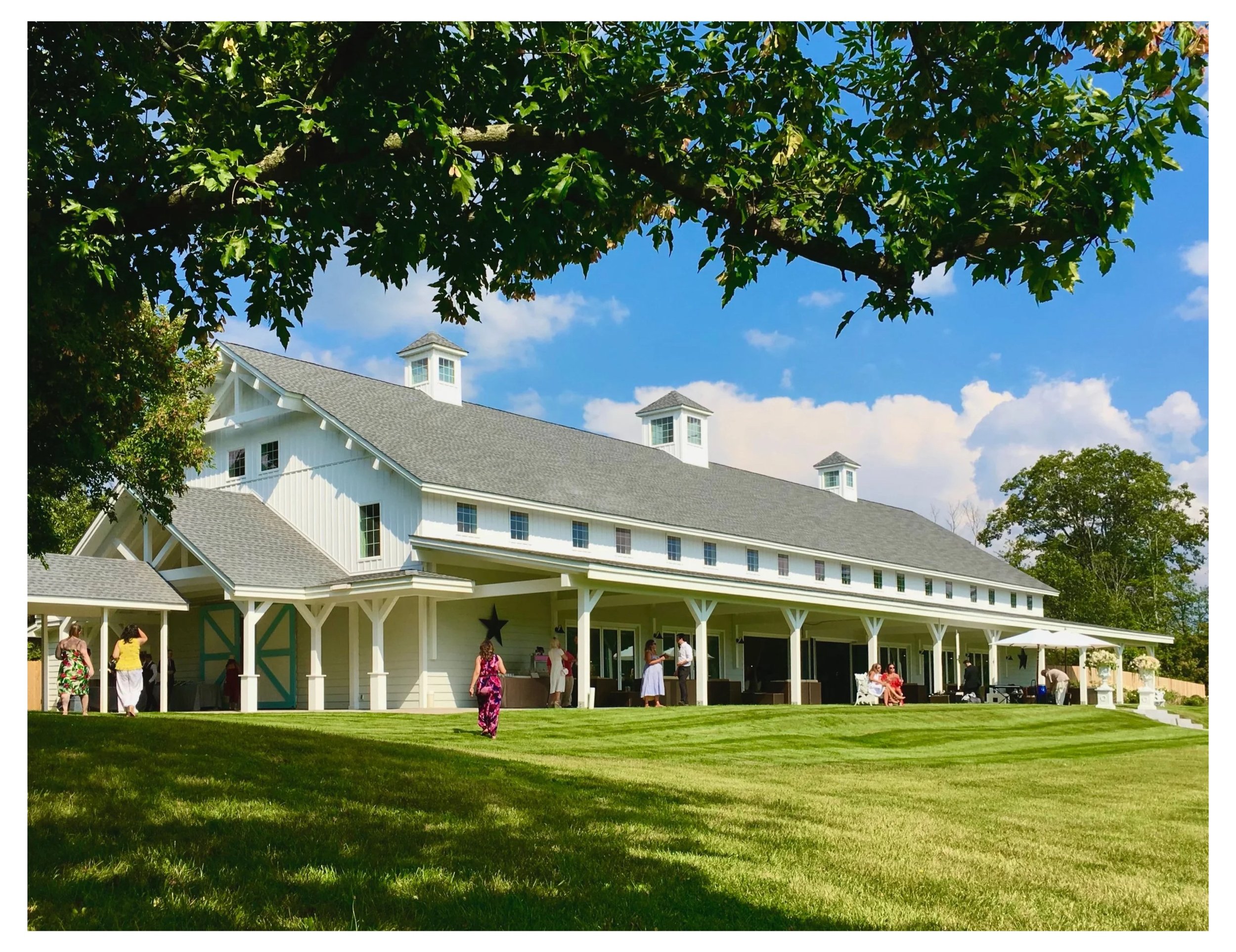 Large white farm house style luxury event and wedding center with front porch.