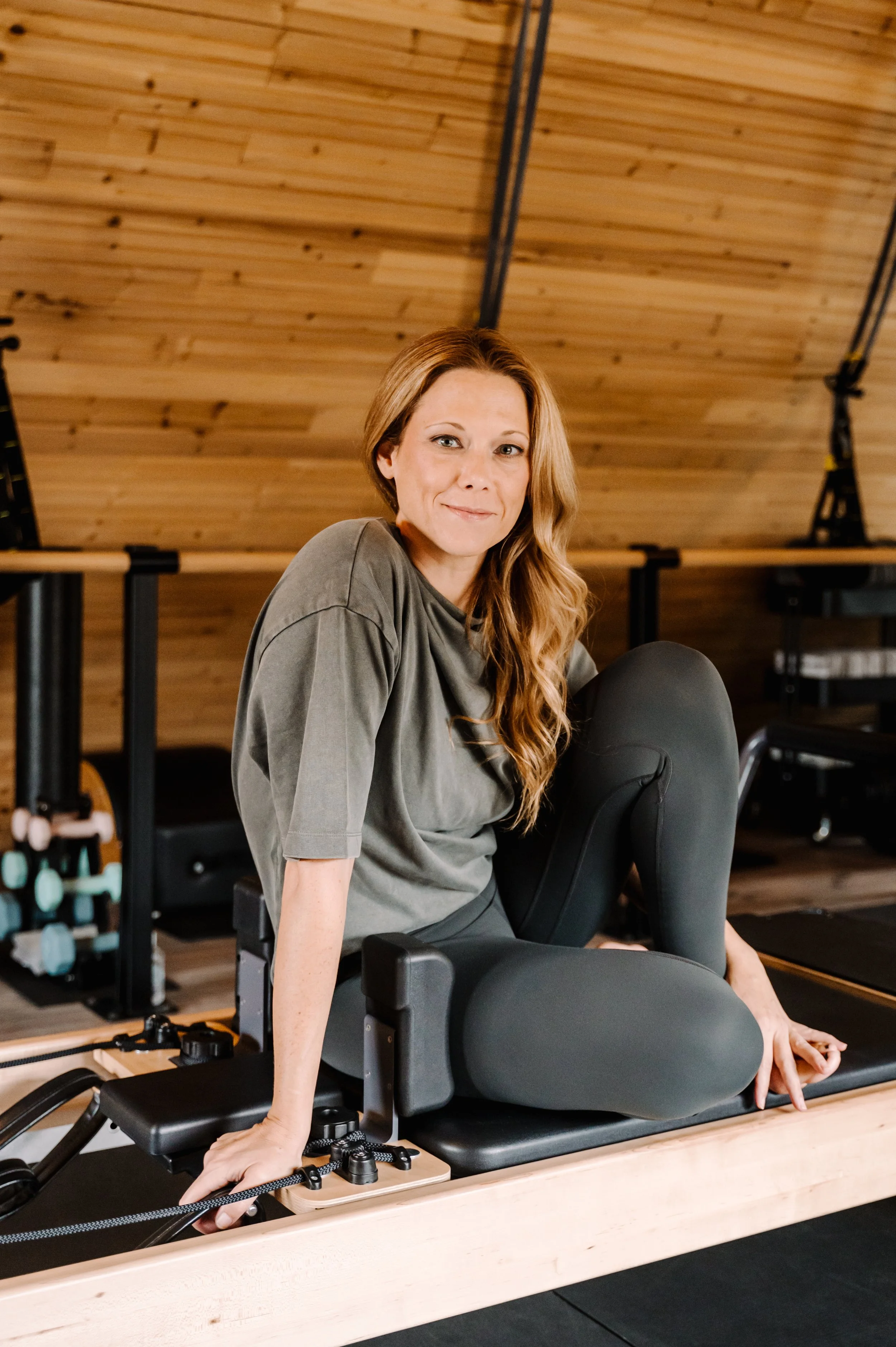 Bee, Pilates instructor, on a reformer at Sculpted By Bee, Grosse Pointe Park, MI