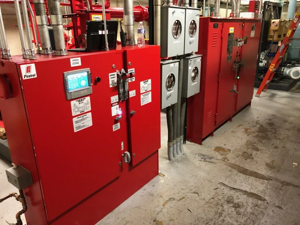 A fire pump room with two fire pump controllers and piping in the background