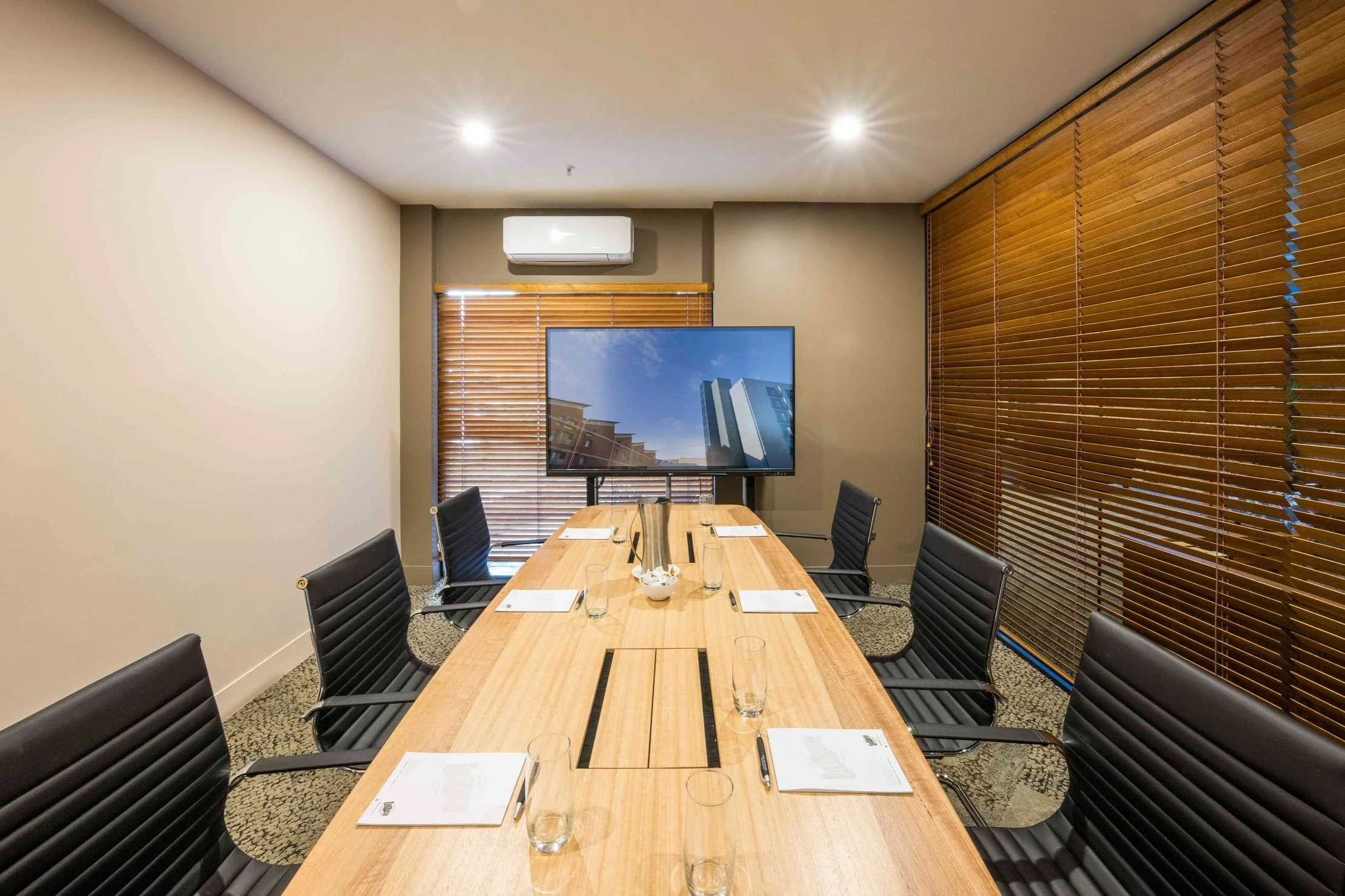 Boardroom with large timber table and TV screen