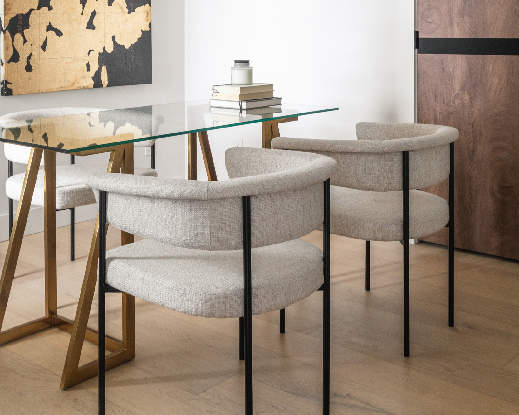 Photo of three chairs and a glass table with books for what does an interior designer do
