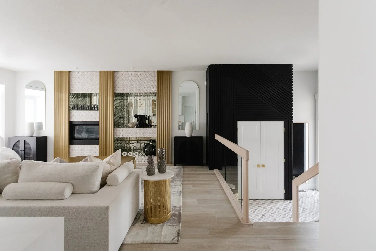 photo of a gold and white luxury living room with a white sofa and gold coffee table facing a fire place and three gold pillars