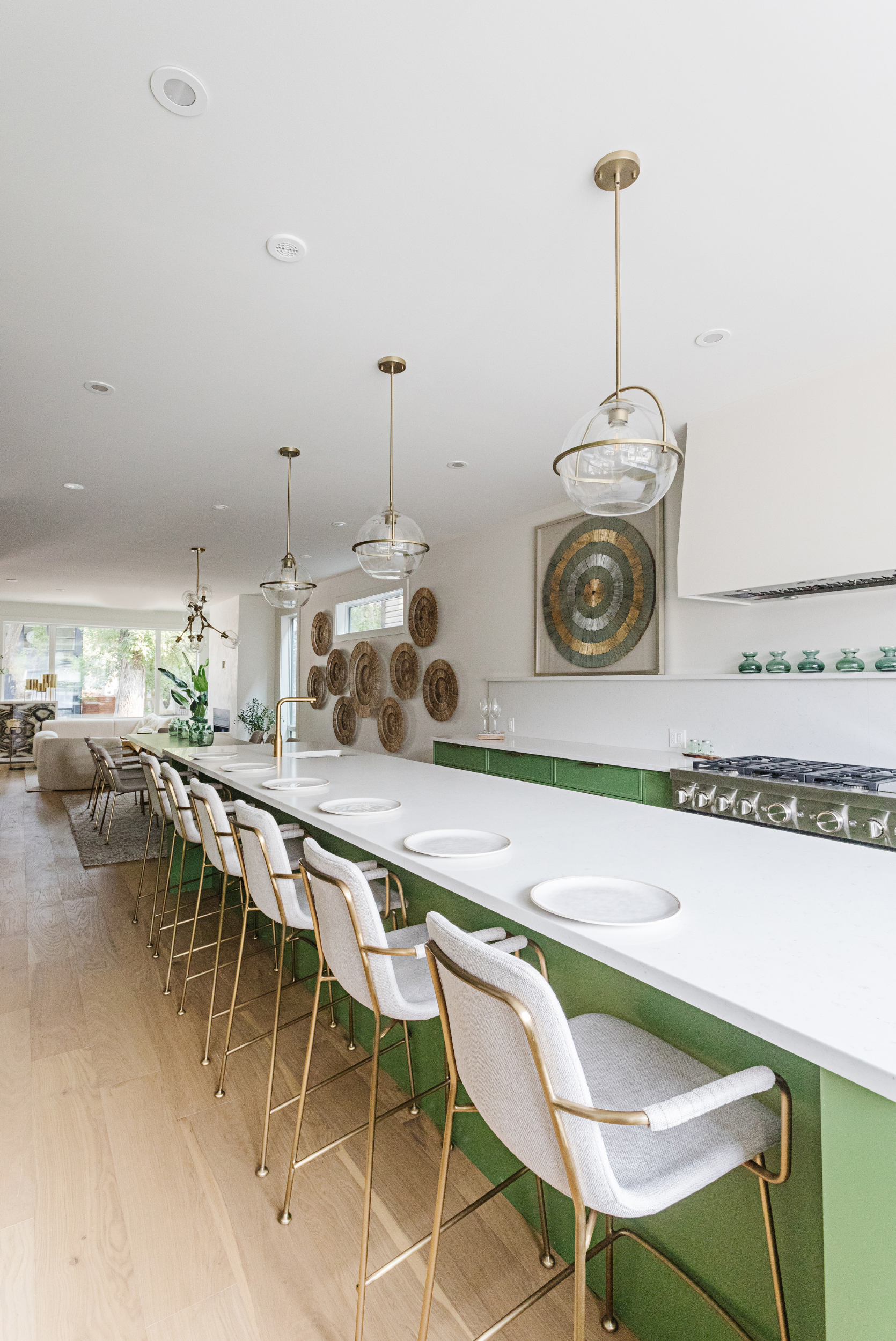 Green cabinets under large kitchen island with bar stools
