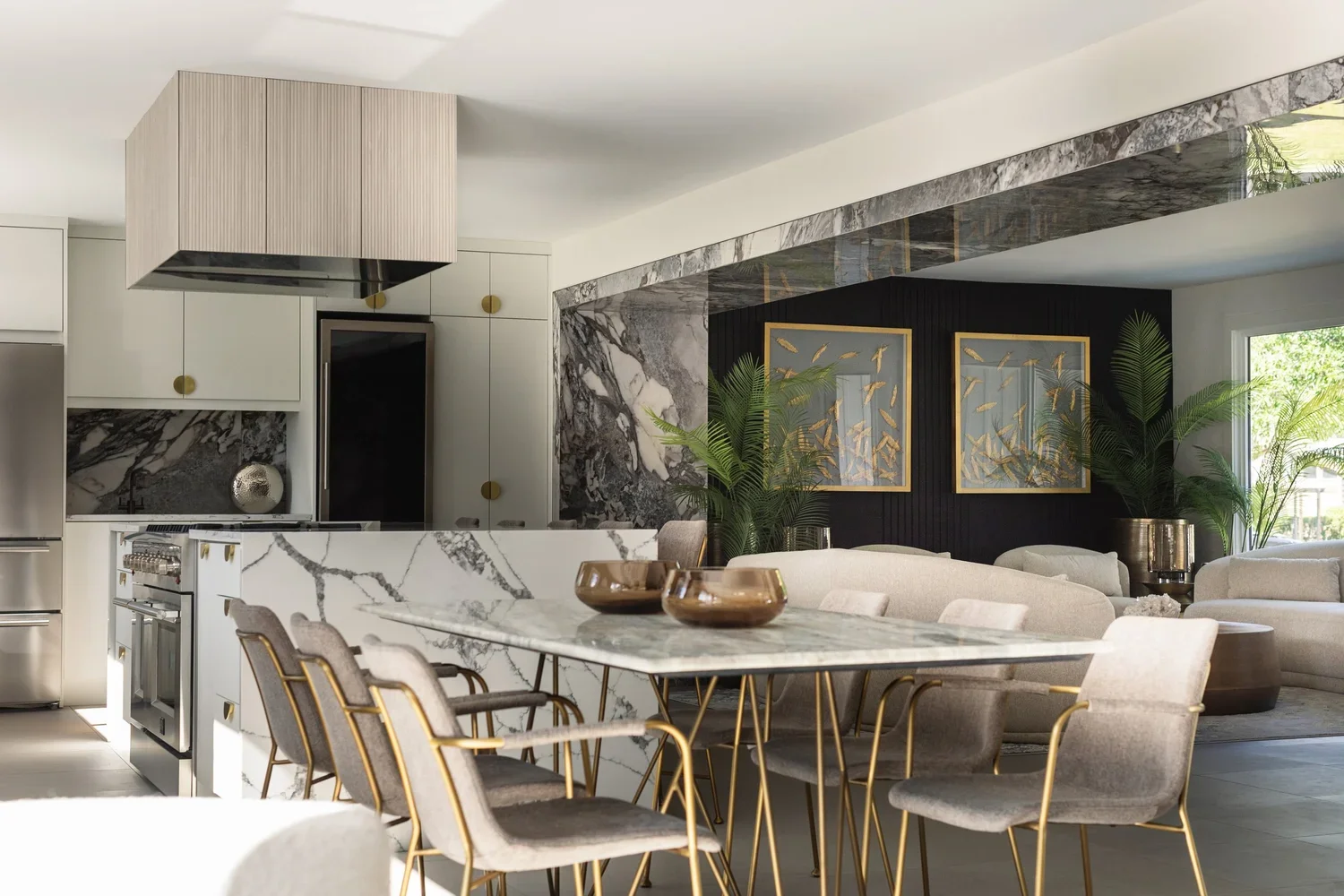 photo of a modern kitchen with white marble counters and a dining table with white chairs and modern decor