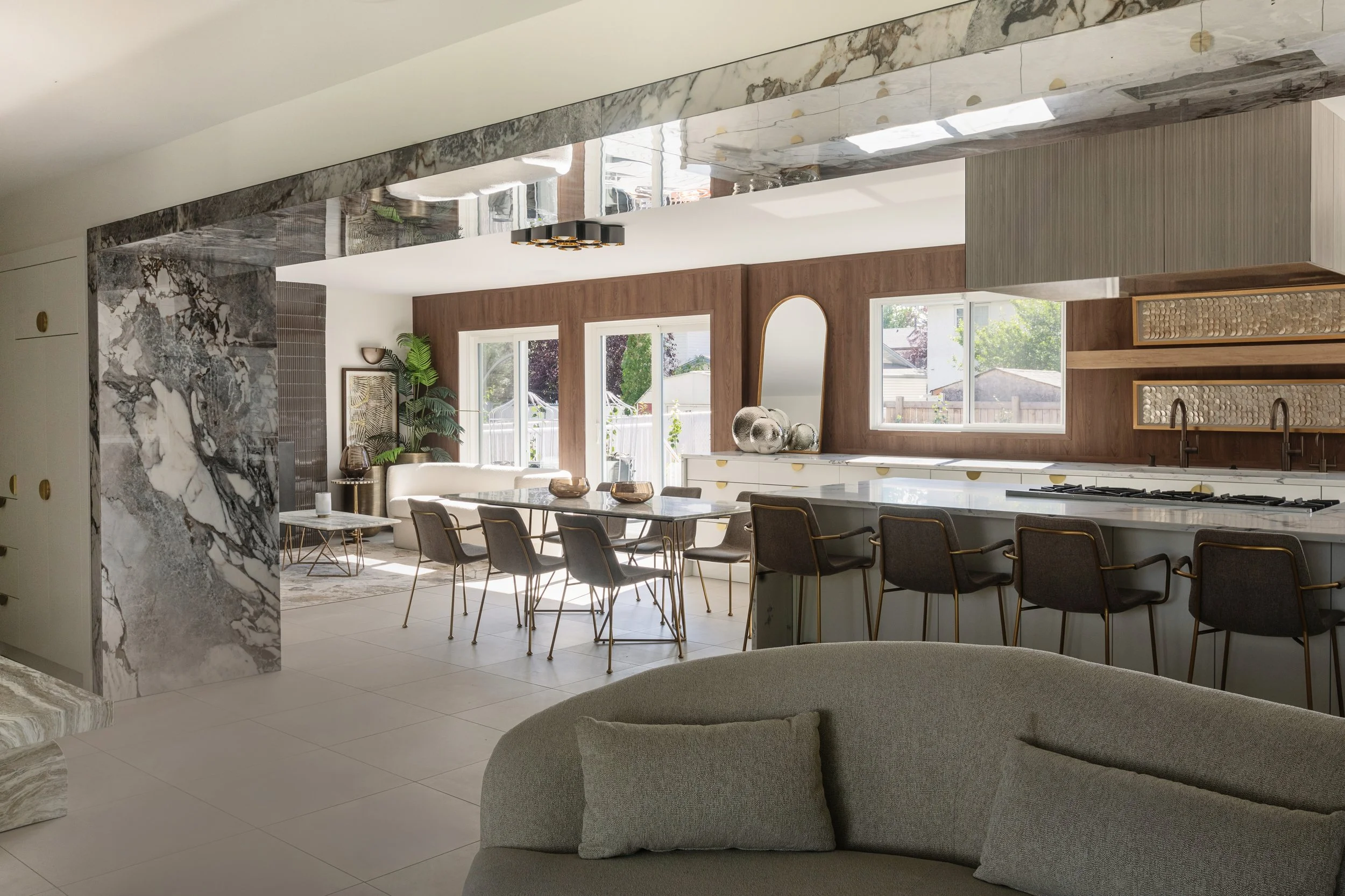 Photo of a modern kitchen with white marble and wood walls and grey sofas and chairs