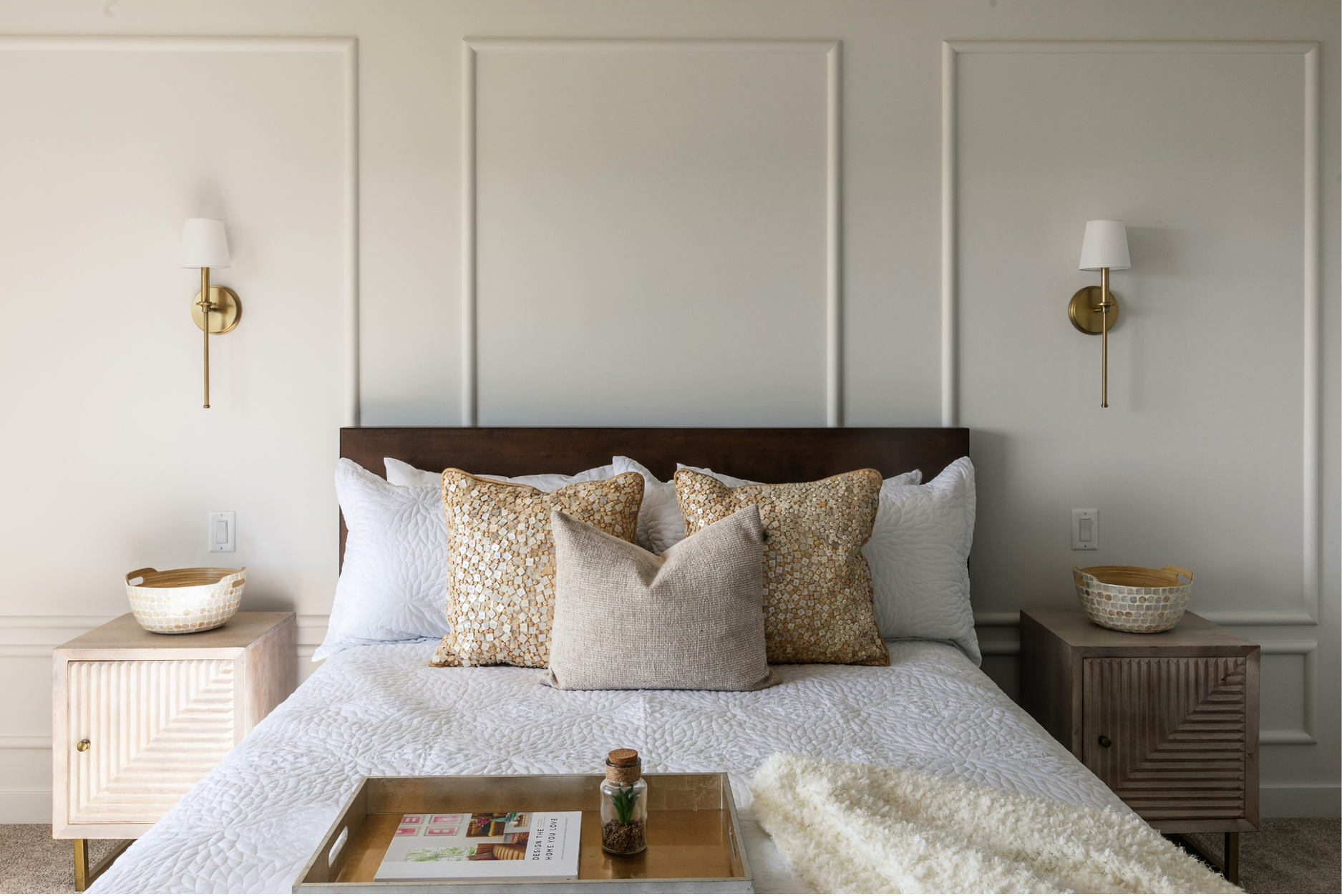 Photo of a white queen-sized bed with throw pillows tray and blanket on top next to nightstands, displaying the different types of beds