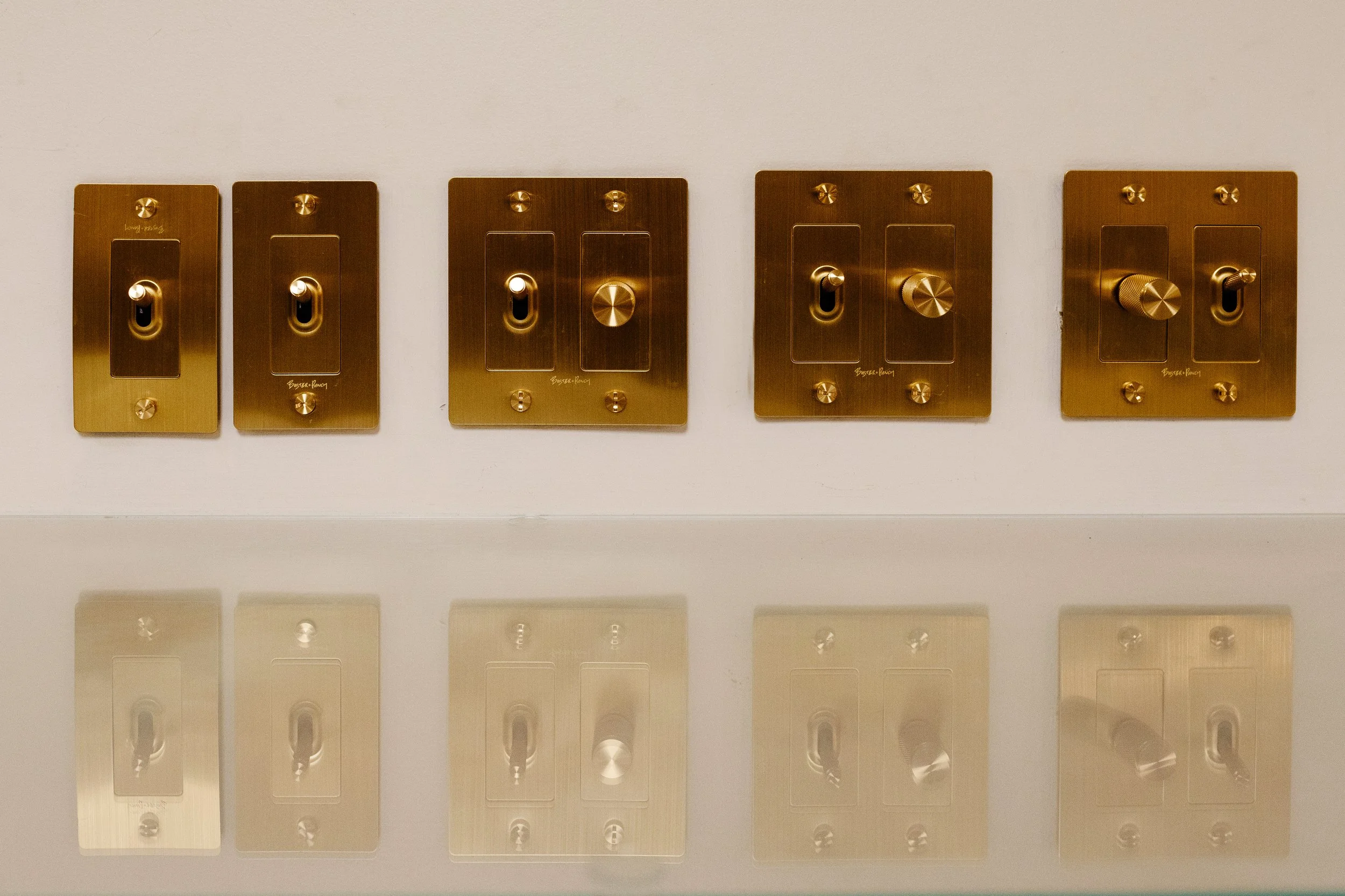 Photo of gold light switch controls in a row on a white wall