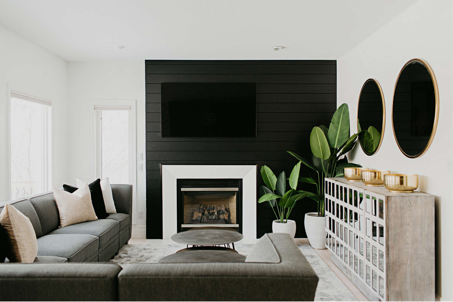 Photo of a black wood panel wall with accent wall decor and a fireplace in a living room