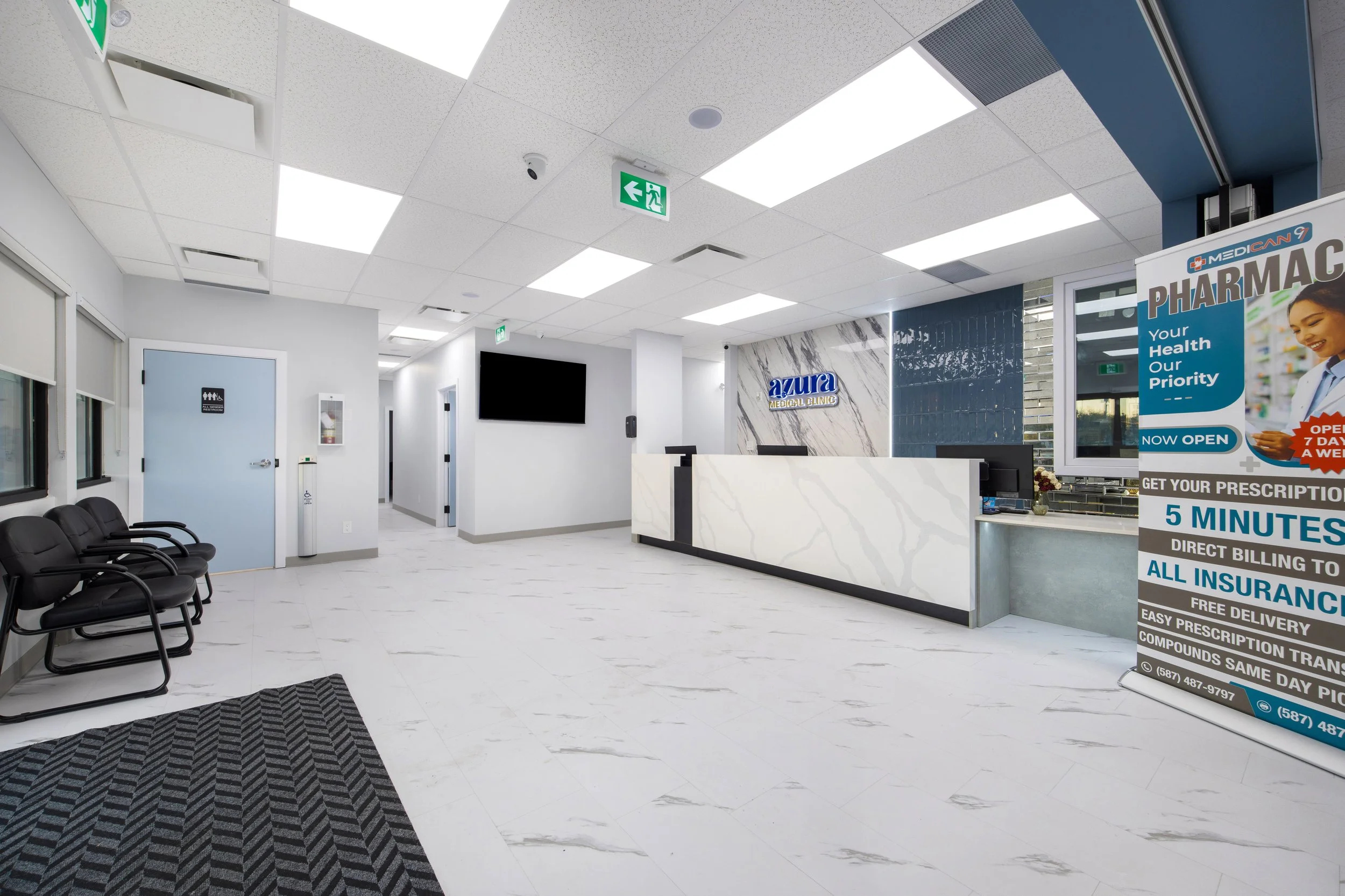 Photo of a white pharmacy clinic white marble floors and a waiting desk facing black waiting chairs