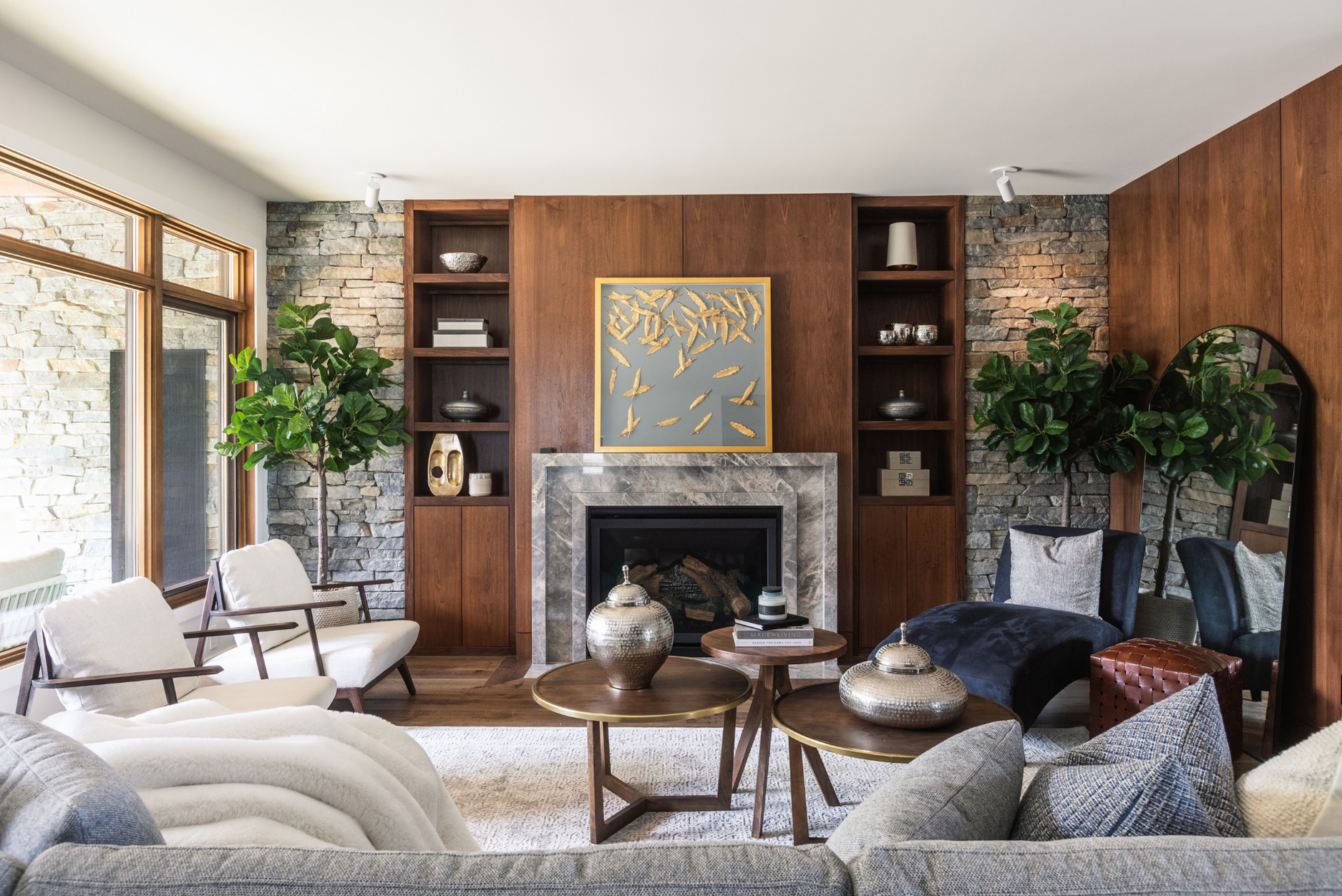 A photo of a modern Art Deco-inspired living room with wood feature walls, stone accents, curved furniture, and intentional art and decor accents.
