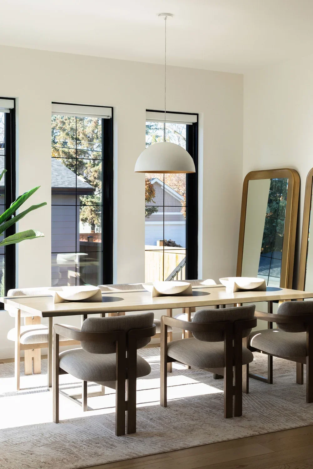 photo of a dining table with white designer chairs and decorative bowls in the centre