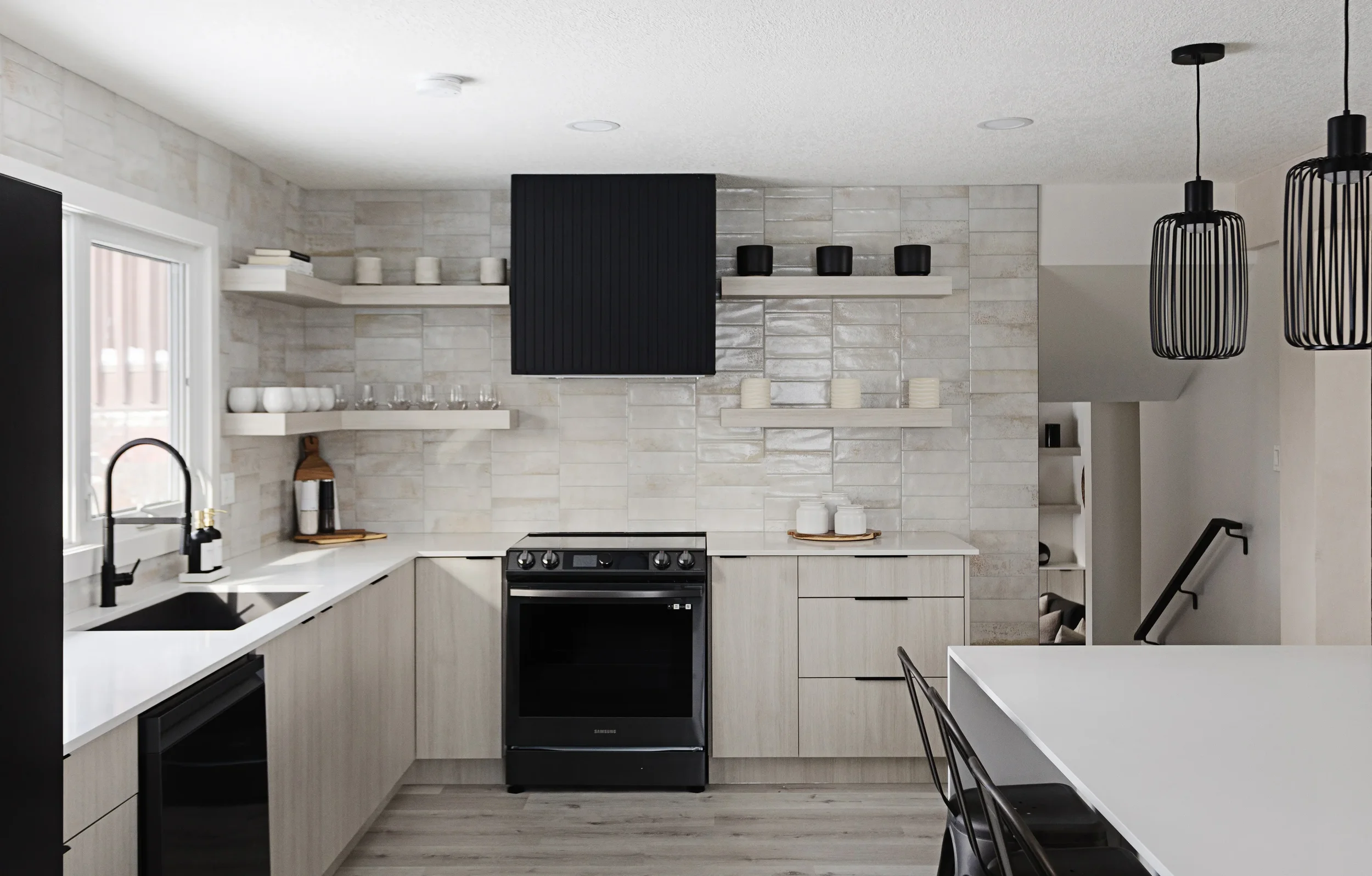 photo of white and black kitchen with a white marble blacksplash and black accents