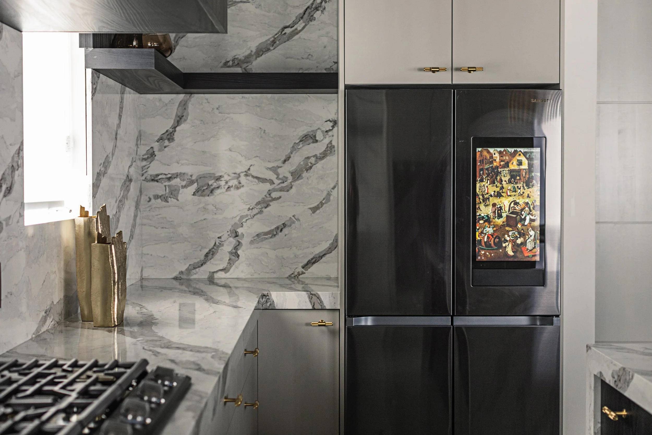 Photo of a smart fridge in a white marble kitchen with gold decor