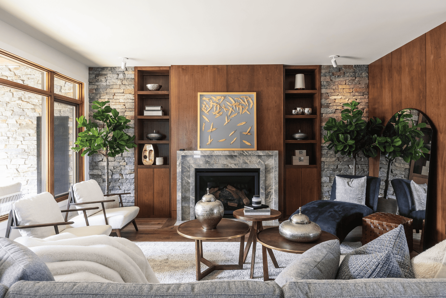 a photo of a modern art deco inspired living room with wood feature walls stone accents curved furniture and intentional art and decor accents
