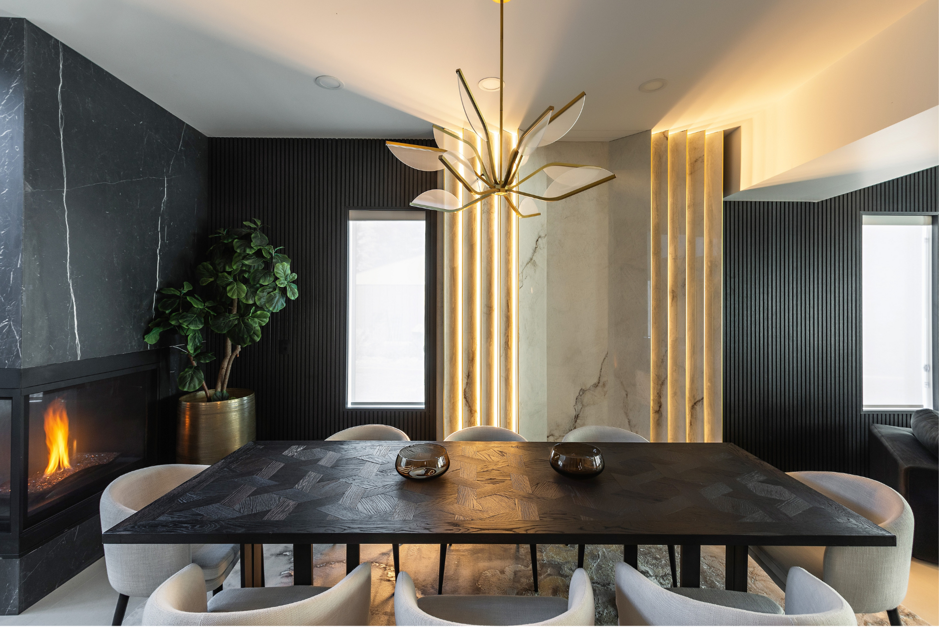 A photo of a luxurious dining room interior with a custom table, statement chandelier, and marble accents