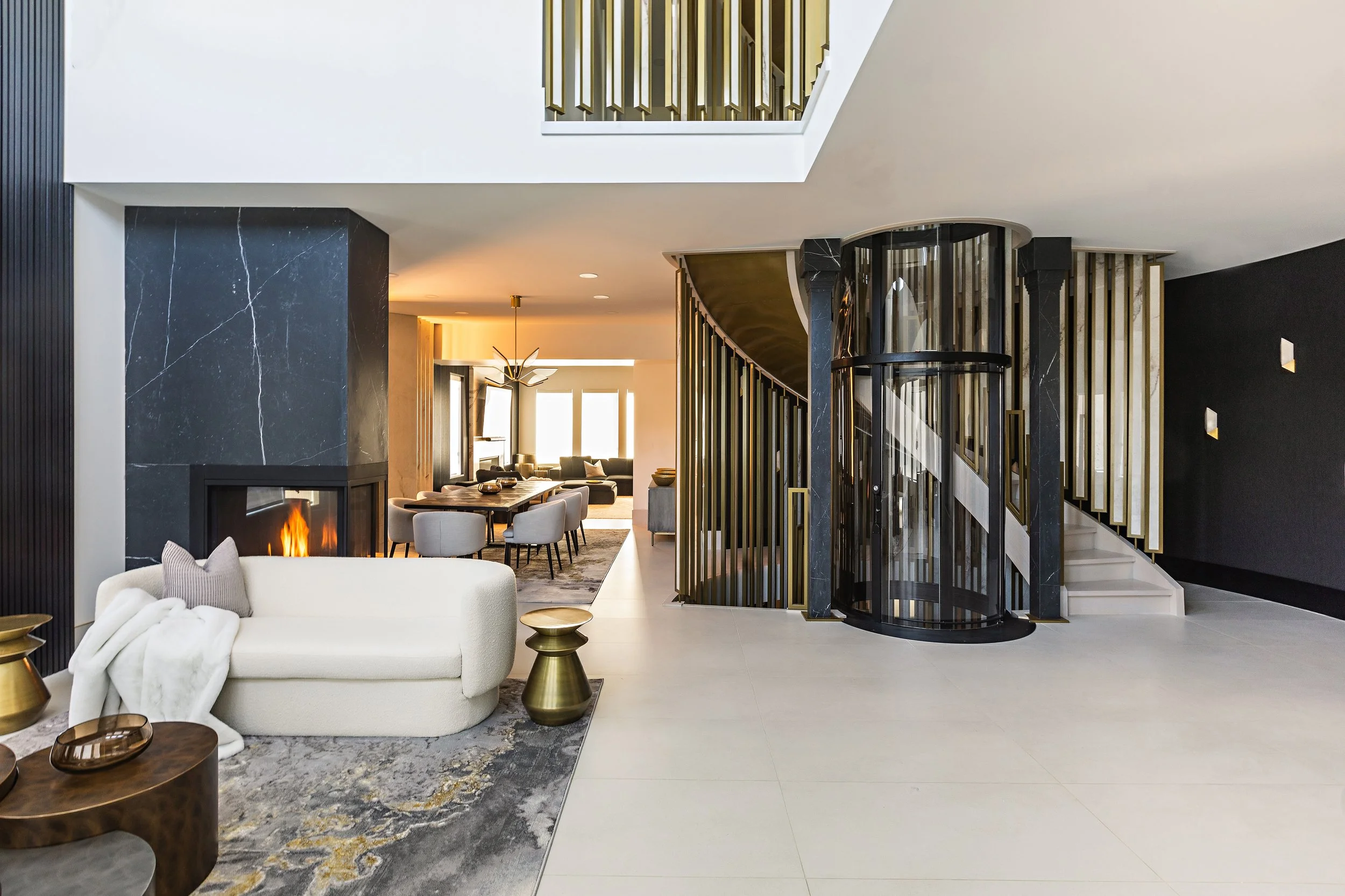Photo of a project by Edmonton contractors with a large luxury residential property featuring a winding staircase, black marble walls, a custom-designed elevator, and luxury home decor