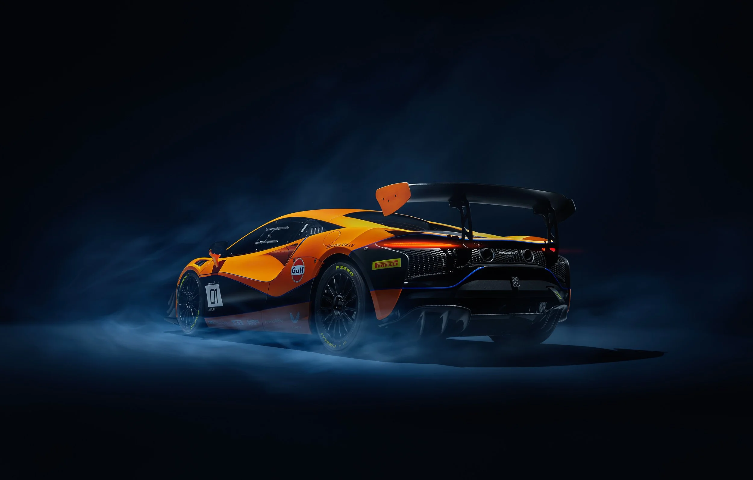 Orange and black McLaren race car with spoilers and logos, back view, set against a dark smoky background.