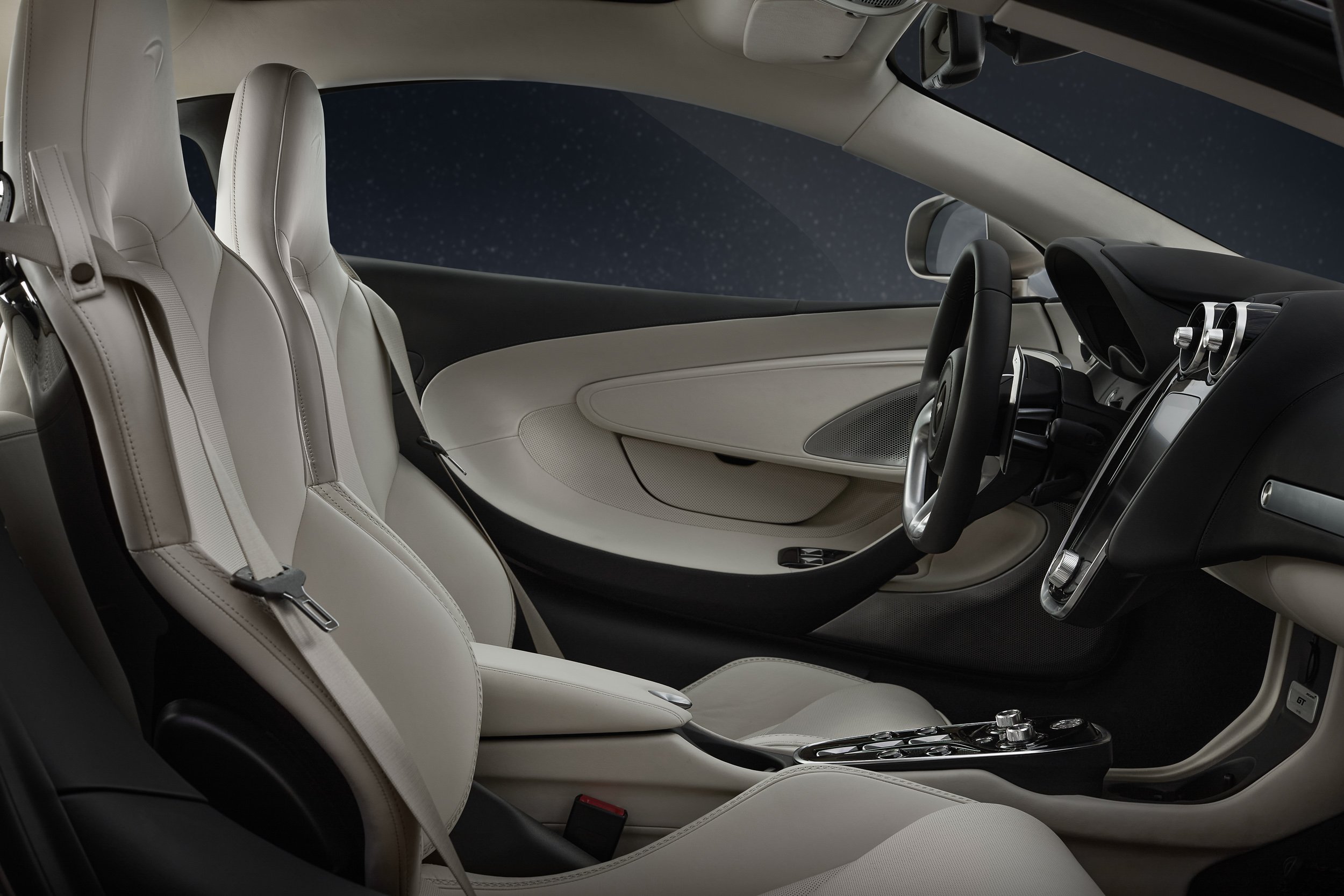 Luxury car interior with beige leather seats, sleek dashboard, and modern steering wheel.