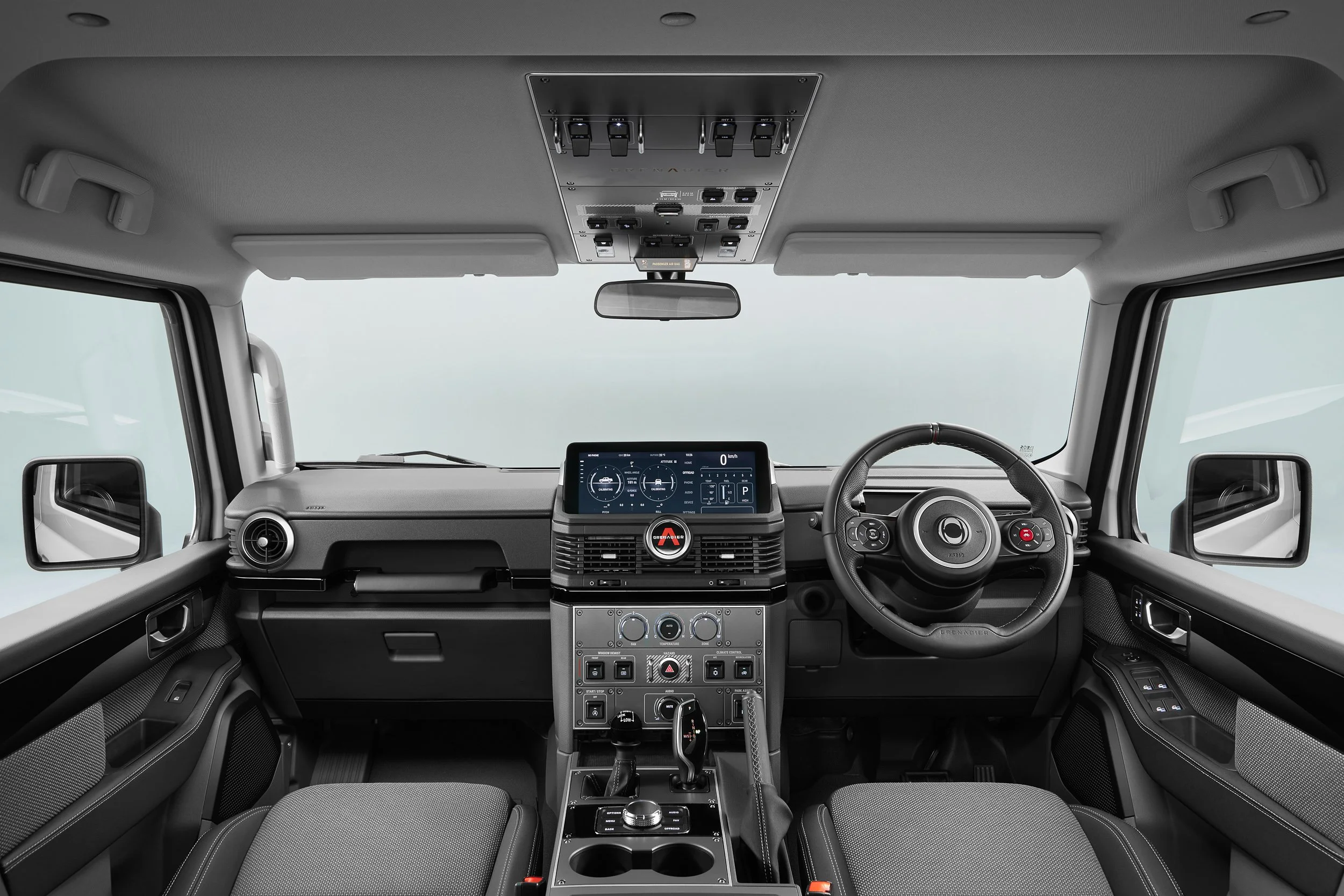 Interior view of a modern car dashboard, featuring a touchscreen display, steering wheel with controls, and various buttons and switches on the center console.