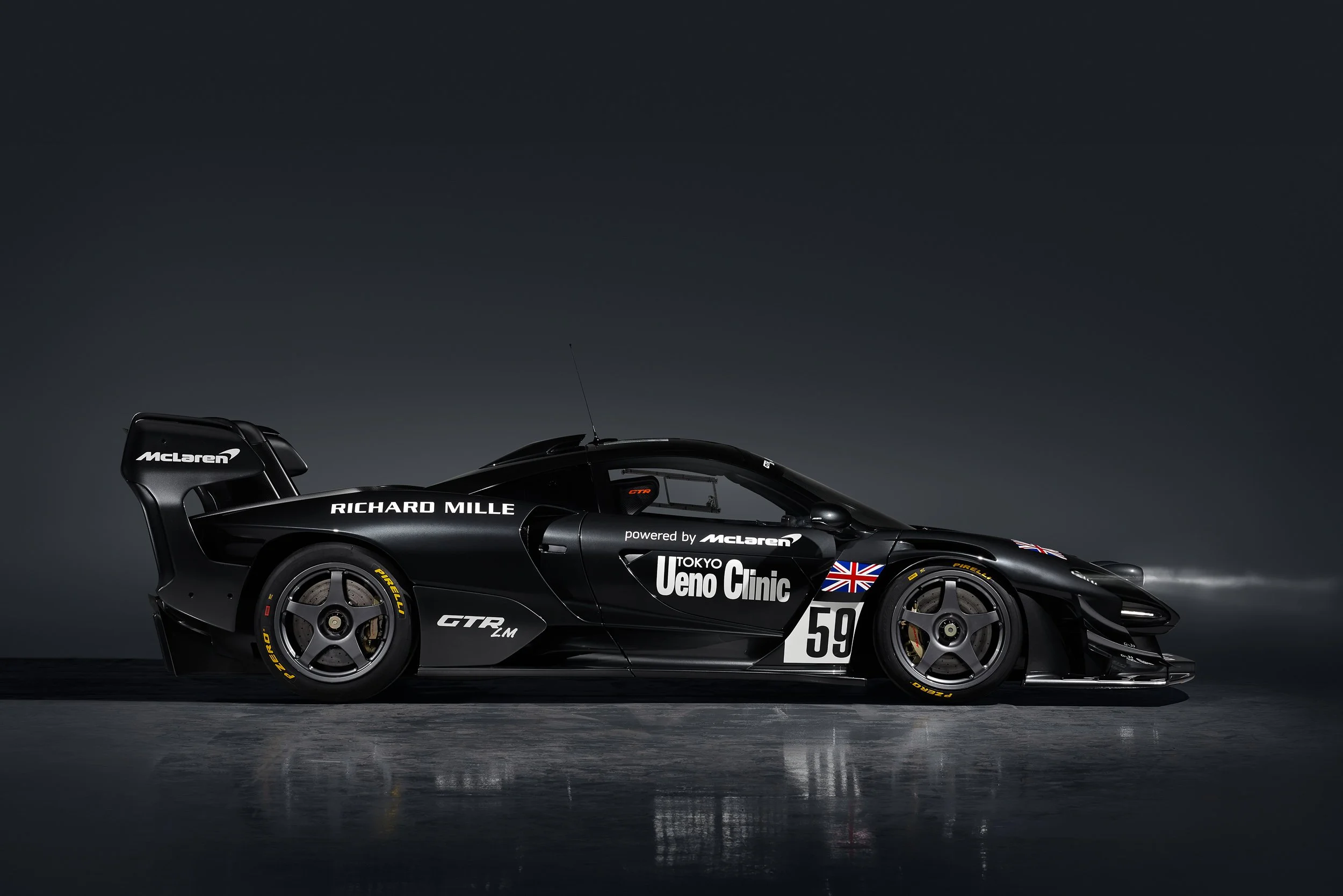 McLaren GTR black race car with Richard Mille branding on a dark background.