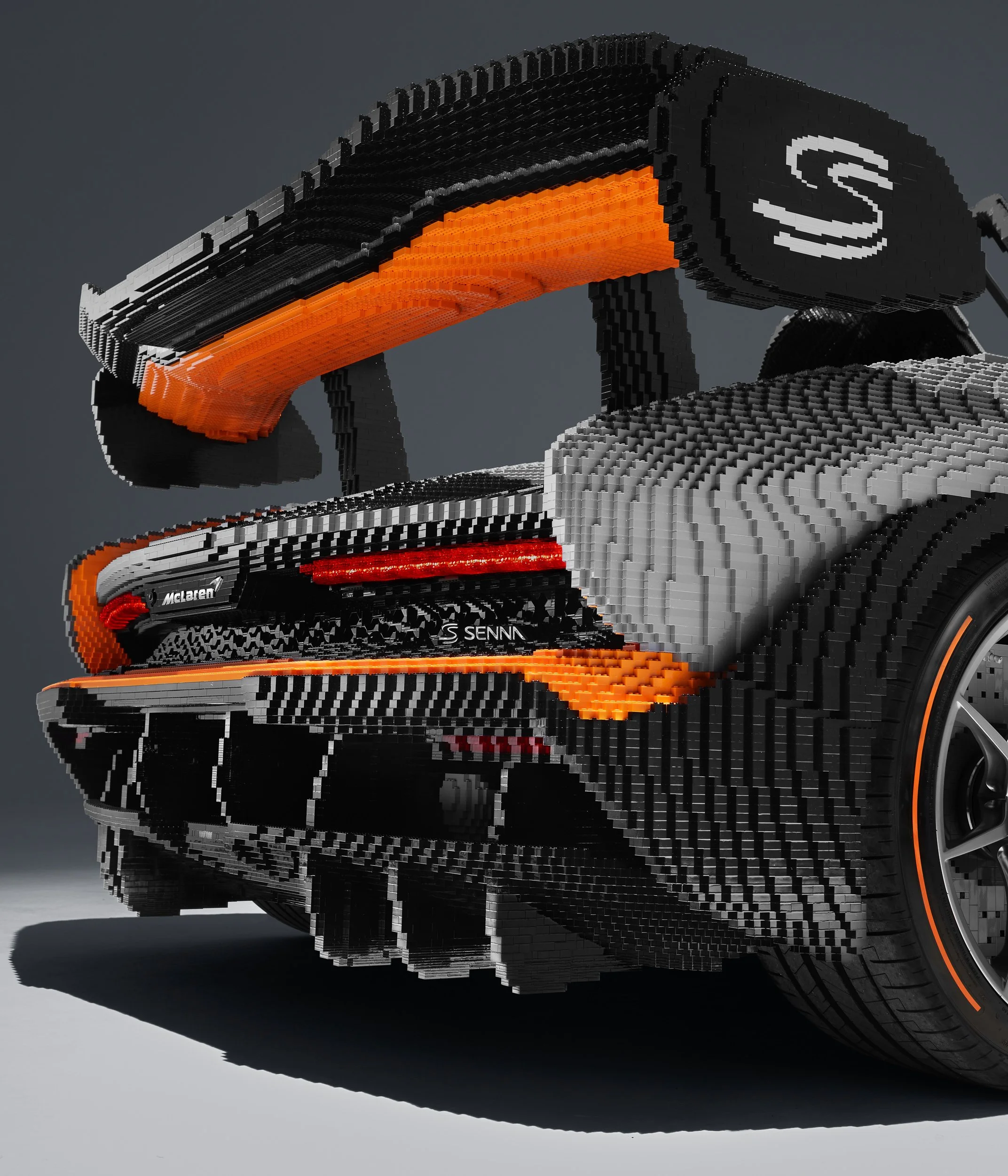 LEGO model of a McLaren Senna car in gray and orange tones.