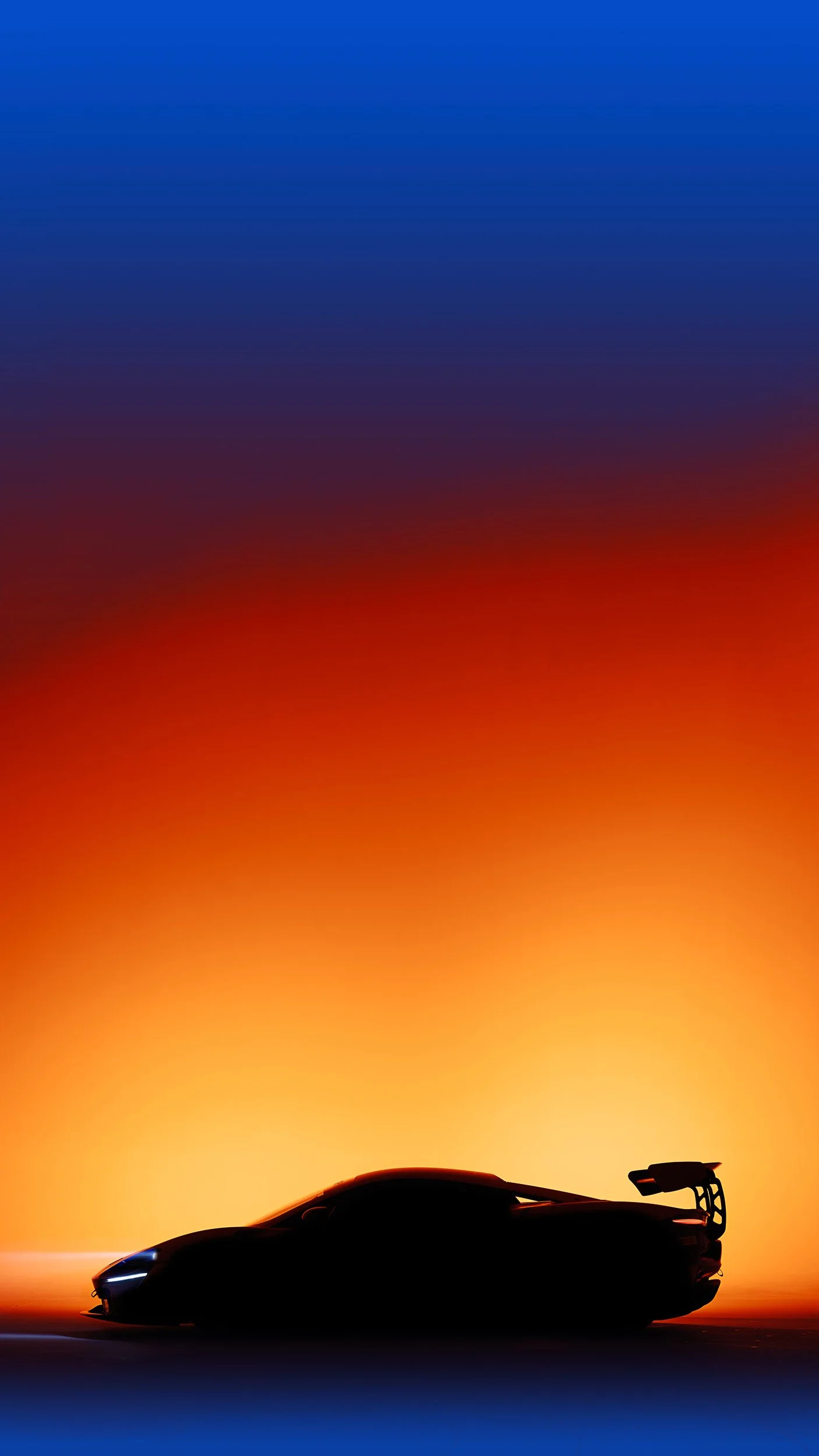 Silhouette of a sports car with a large rear wing against an orange and blue gradient background.