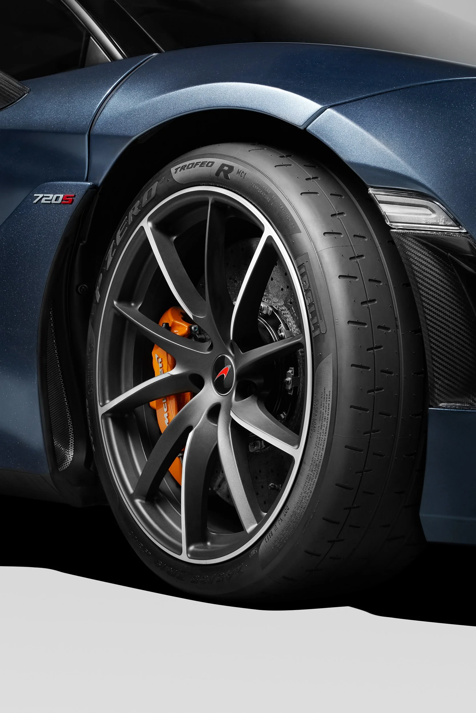 Close-up of a car's wheel highlighting the rim, brake caliper, and tire on a sports car.