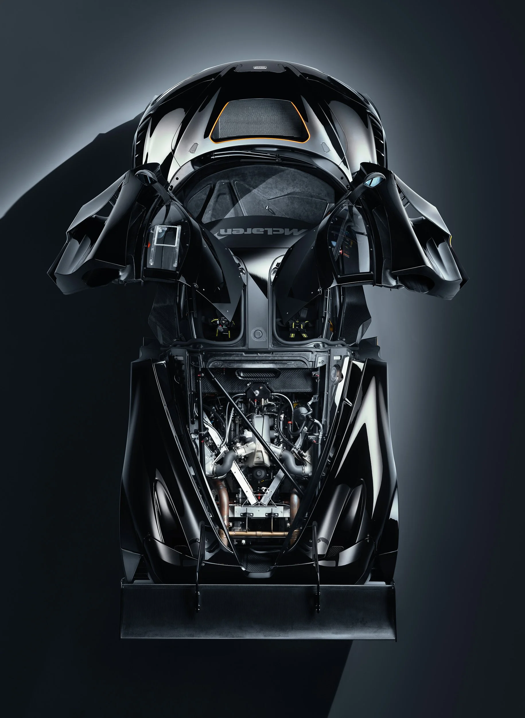 Top view of a McLaren supercar with open doors and exposed engine