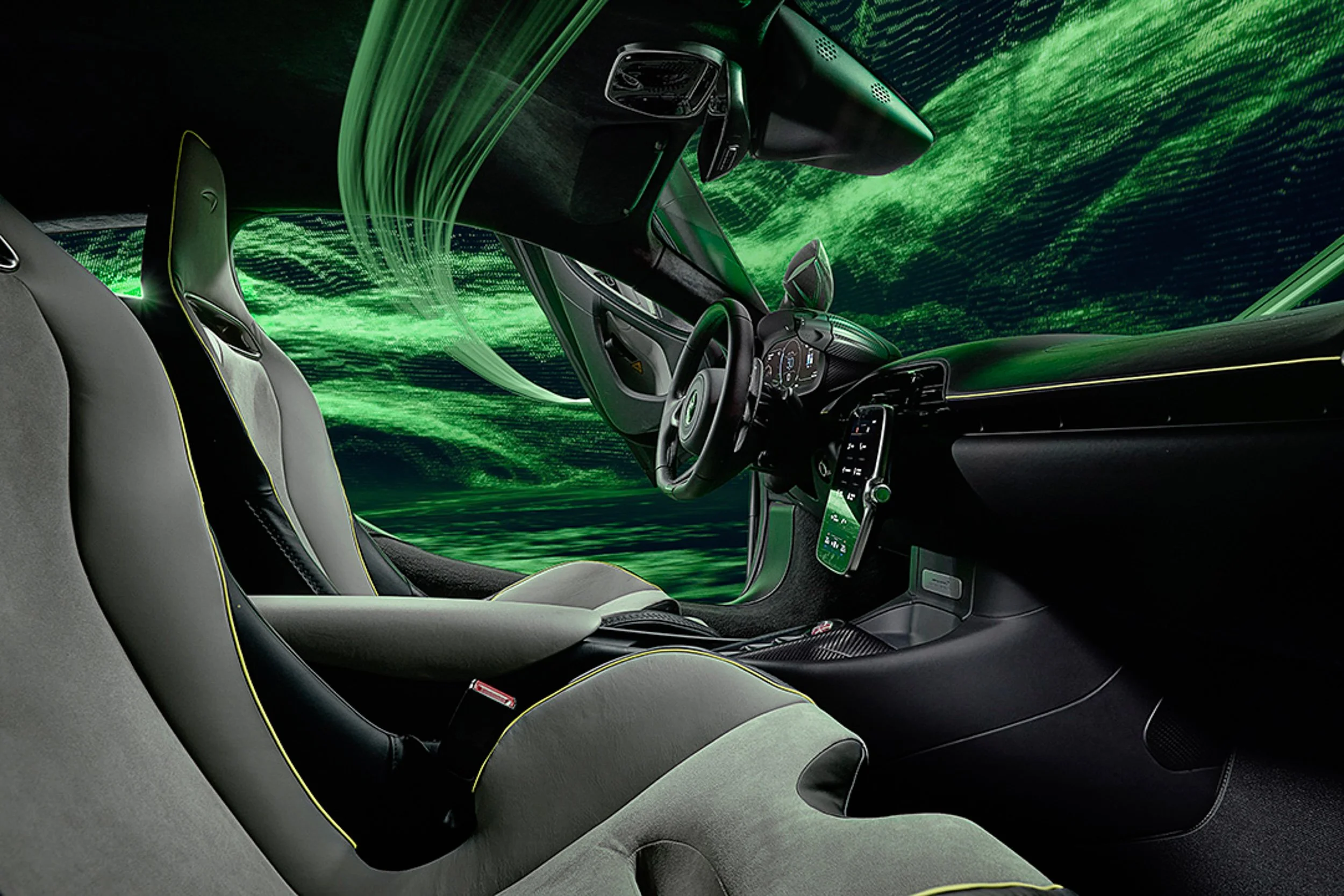 Interior of a modern sports car with sleek design and advanced dashboard, featuring green ambient lighting and two bucket seats.